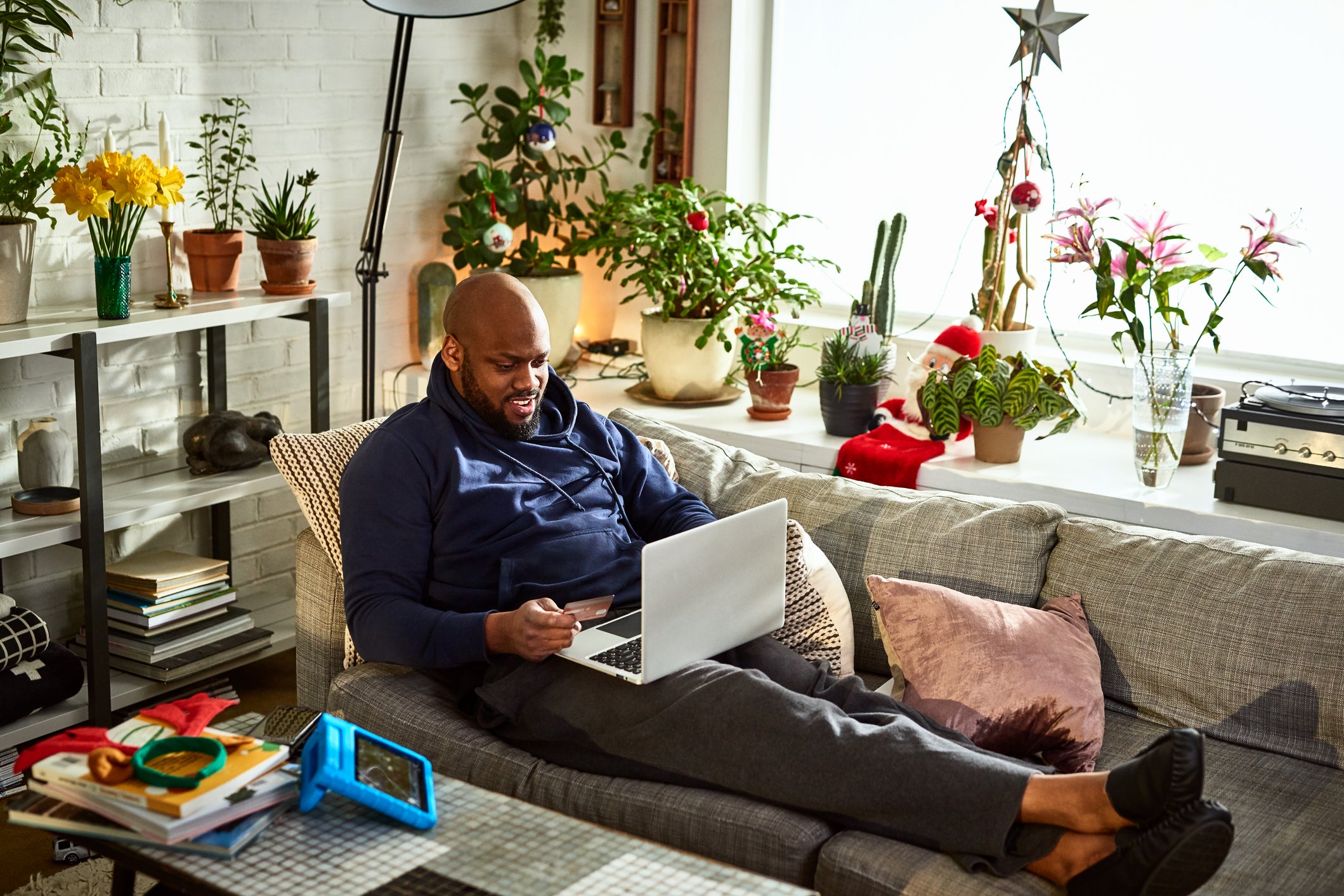 Man using laptop with feet up on sofa