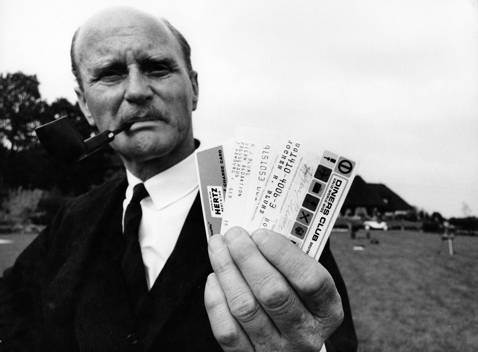 Black and white photos of man holding Diners Club credit cards in 1960