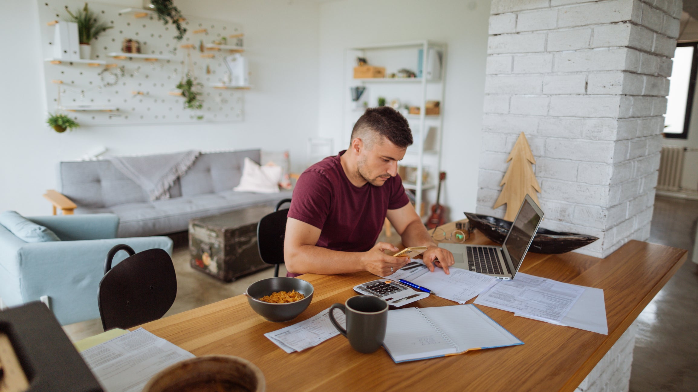 Young man at home, paying bills online