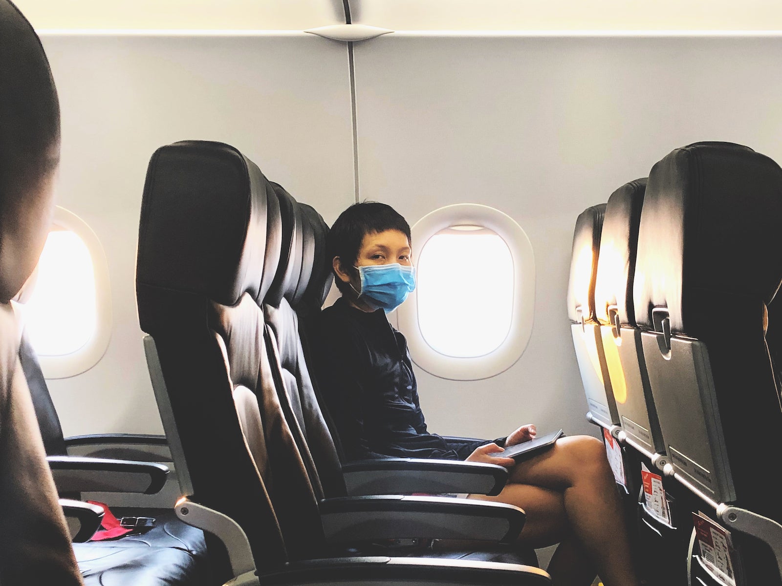 Portrait Of Man Wearing Mask Sitting In Airplane