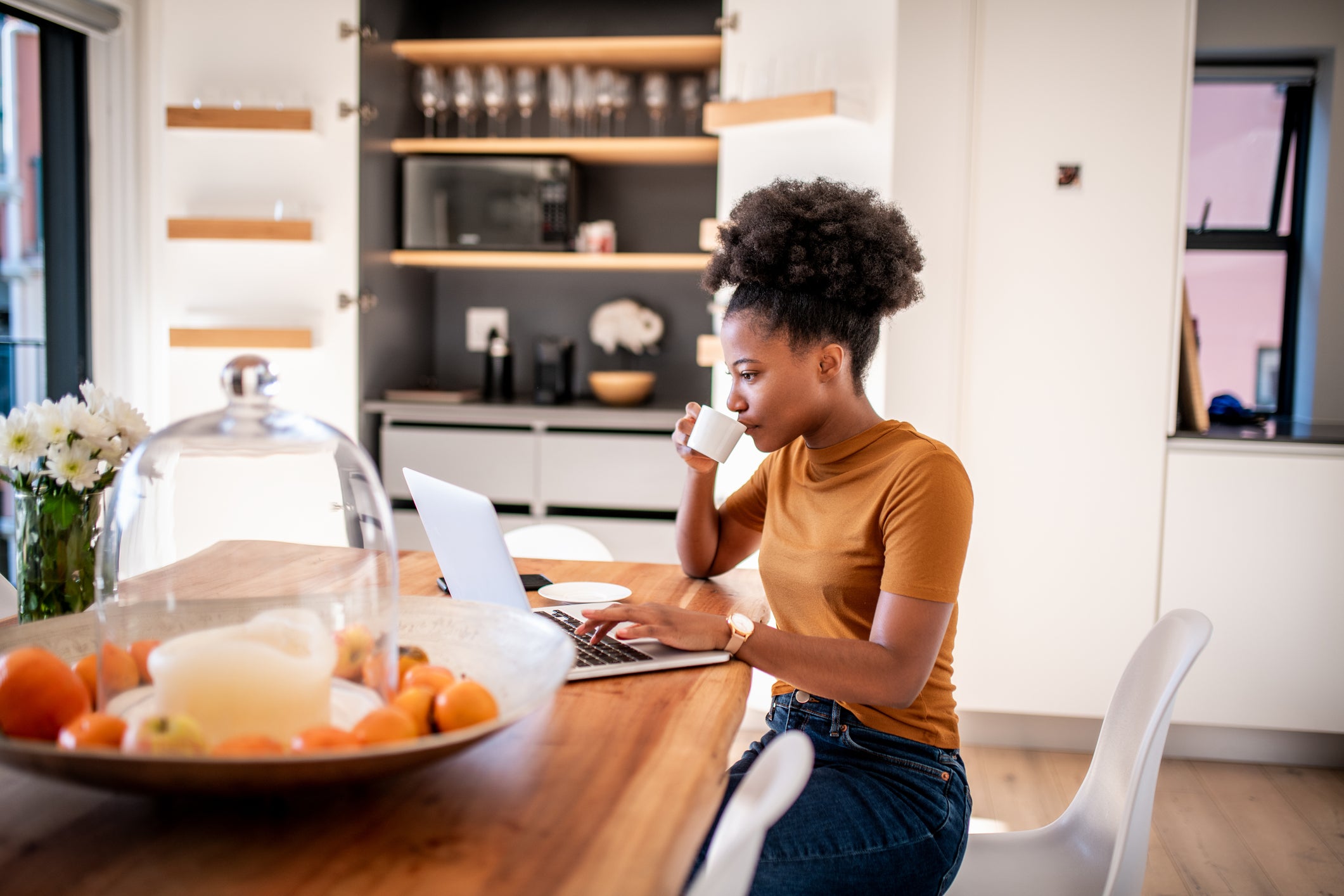 woman using laptop at kitchen table