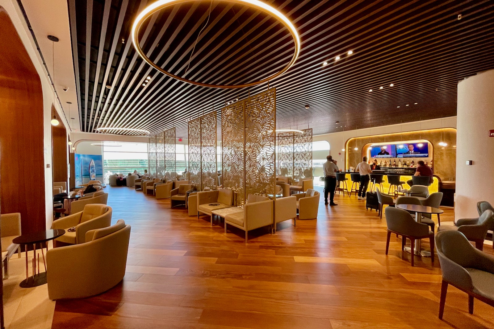 a large, open airport lounge with ample seating and lots of natural light from large windows
