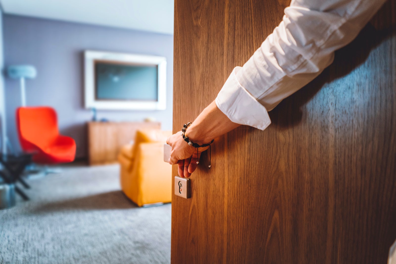 Man hand opening the door of the luxurious hotel room