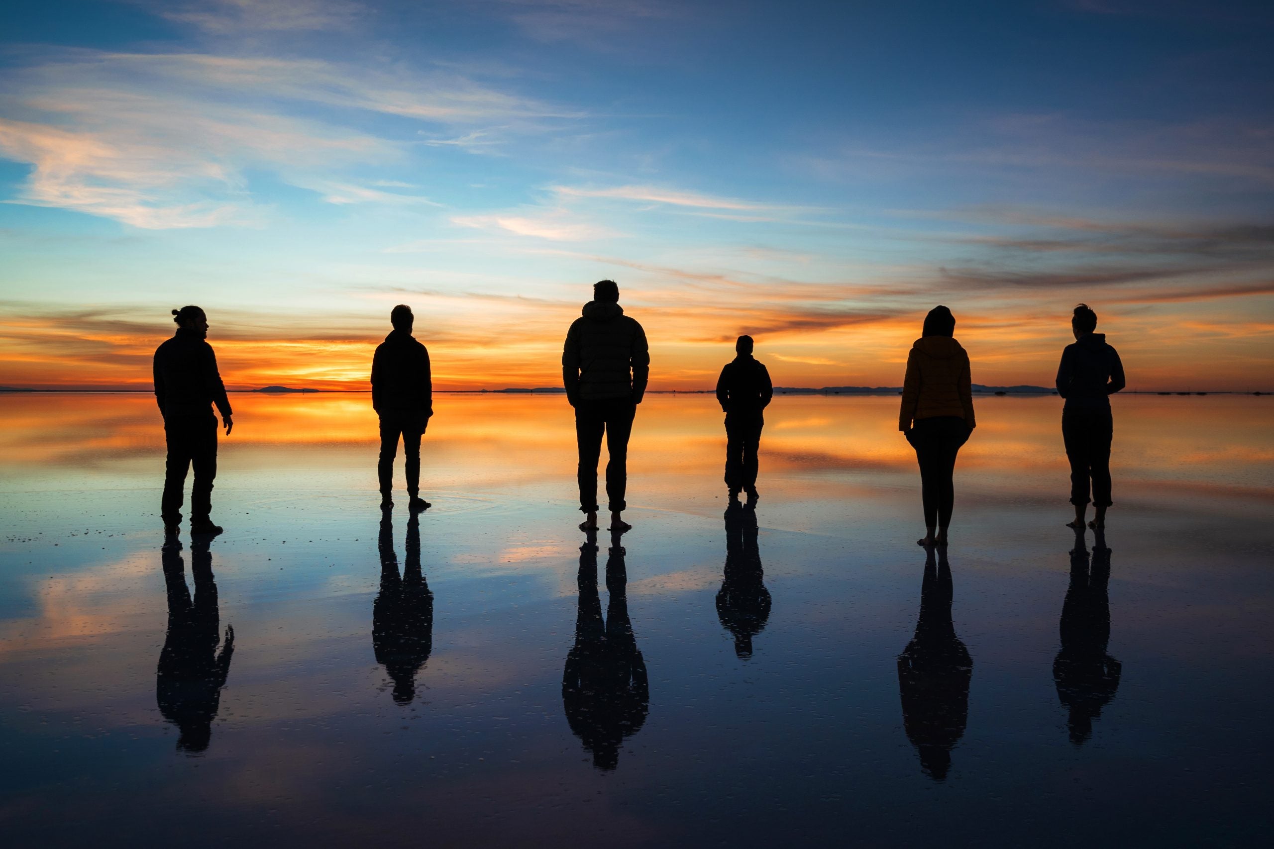 Diverse,Group,Of,People,Against,Sunrise,,Silhouette,Of,Travellers,At