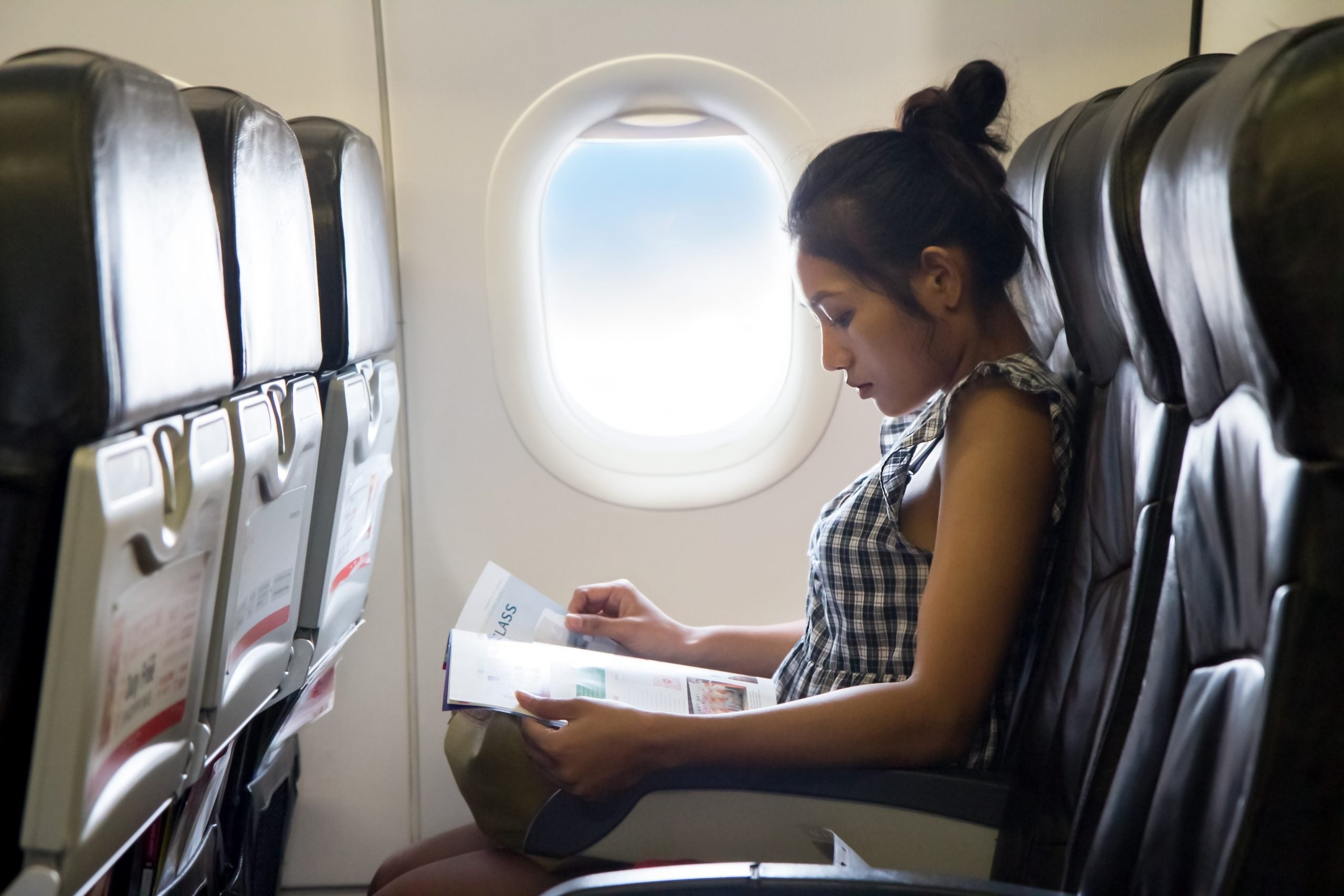 Young,Woman,Travels,In,A,Chair,Of,The,Airplane.,Passengers