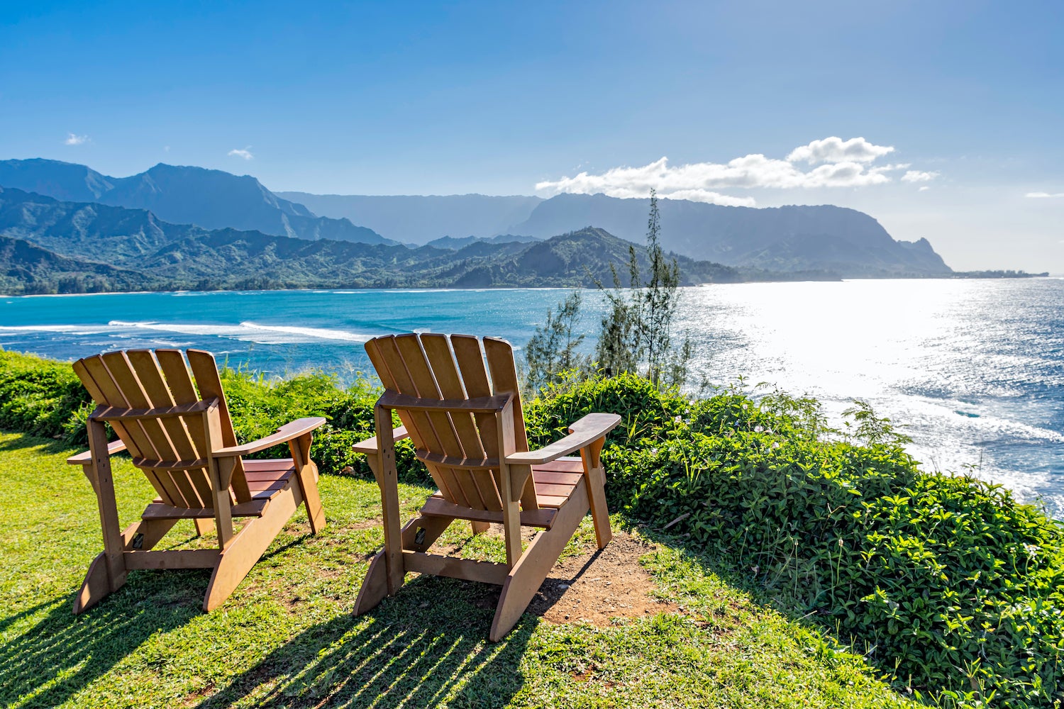 Lounging chairs overlooking Hanalei Bay and the Na Pali coast Princeville Kauai Hawaii USA in the late afternoon sun