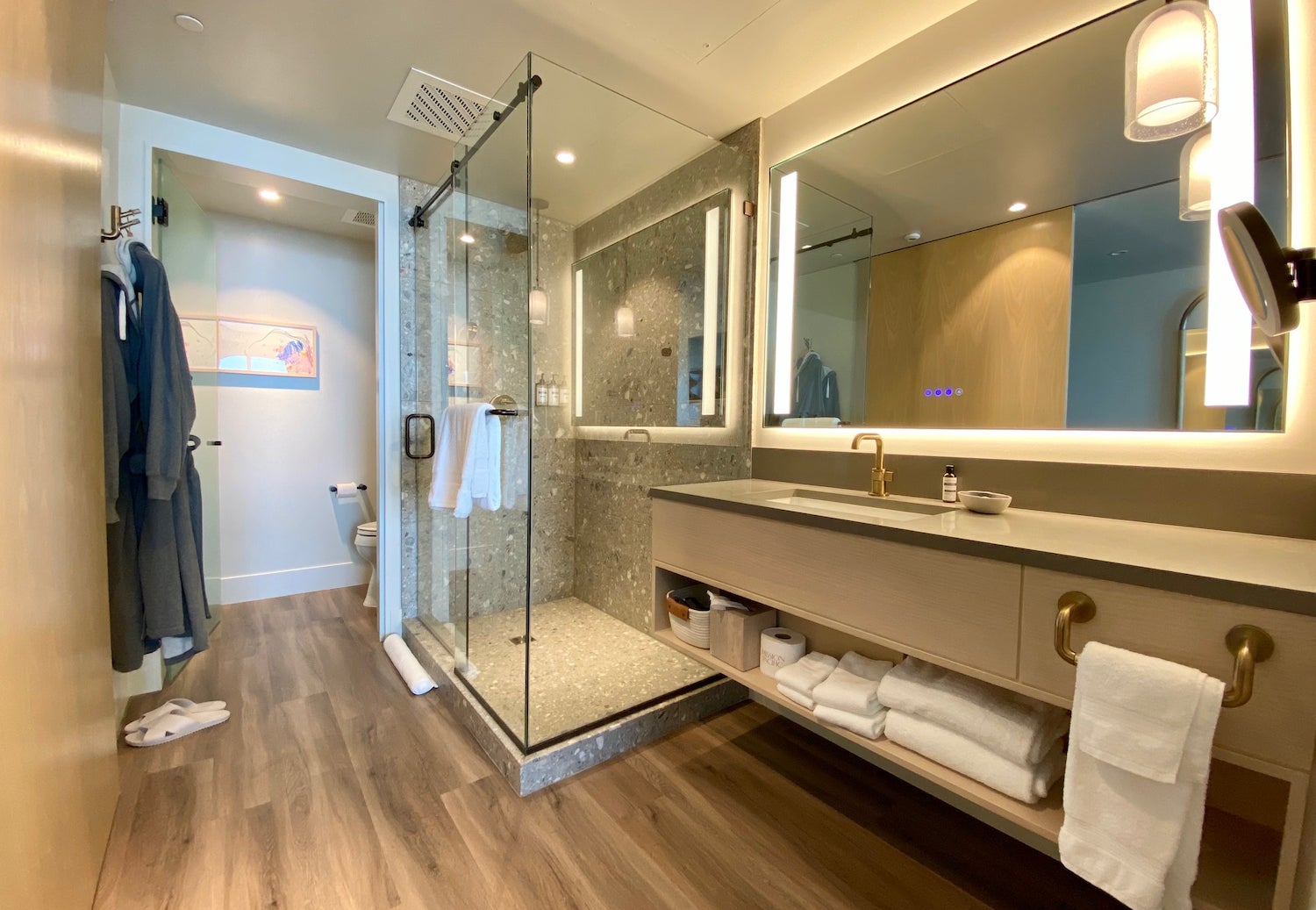 Hotel bathroom with a vanity next to a glassdoor shower