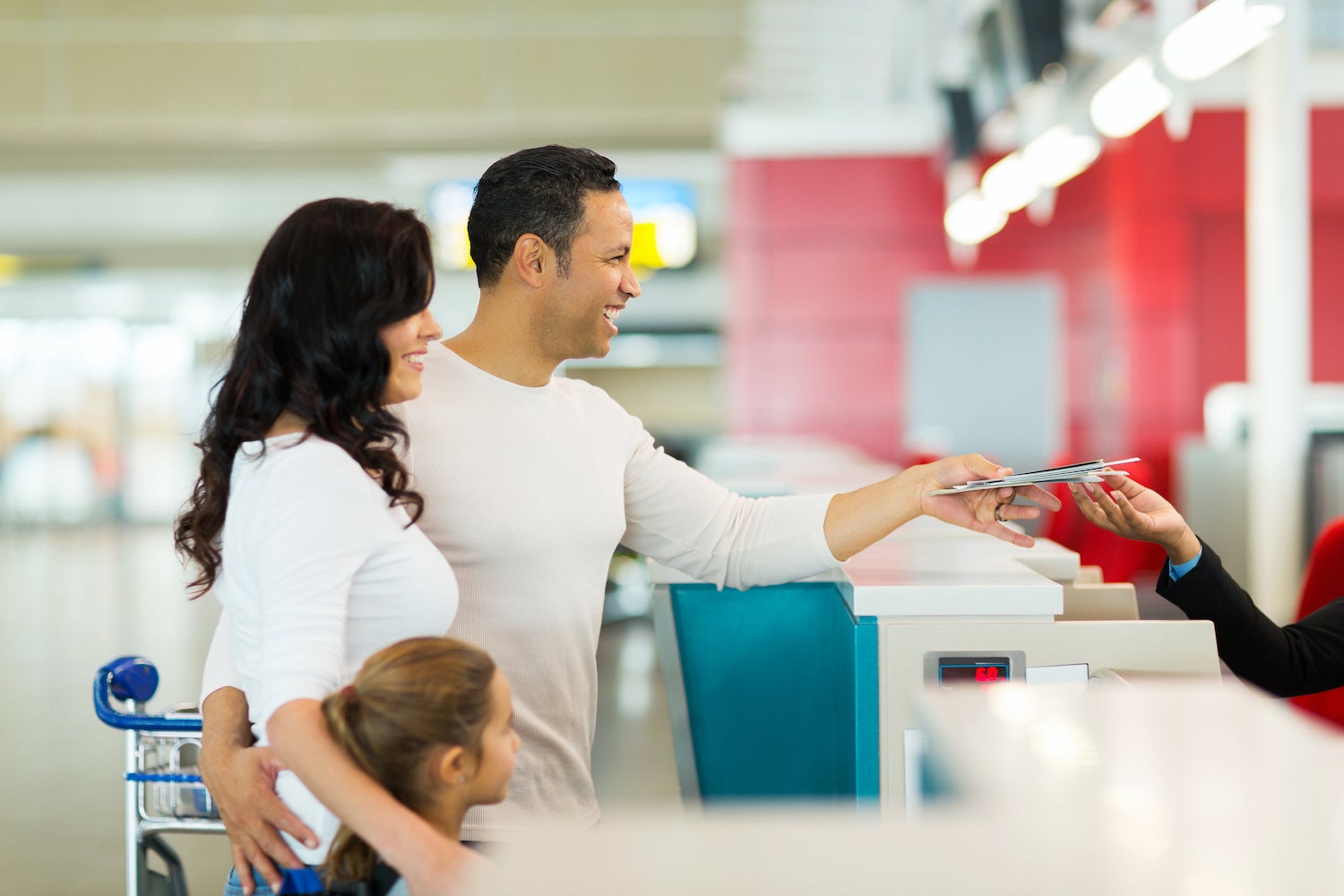 family handing over air ticket at airport at check in counter