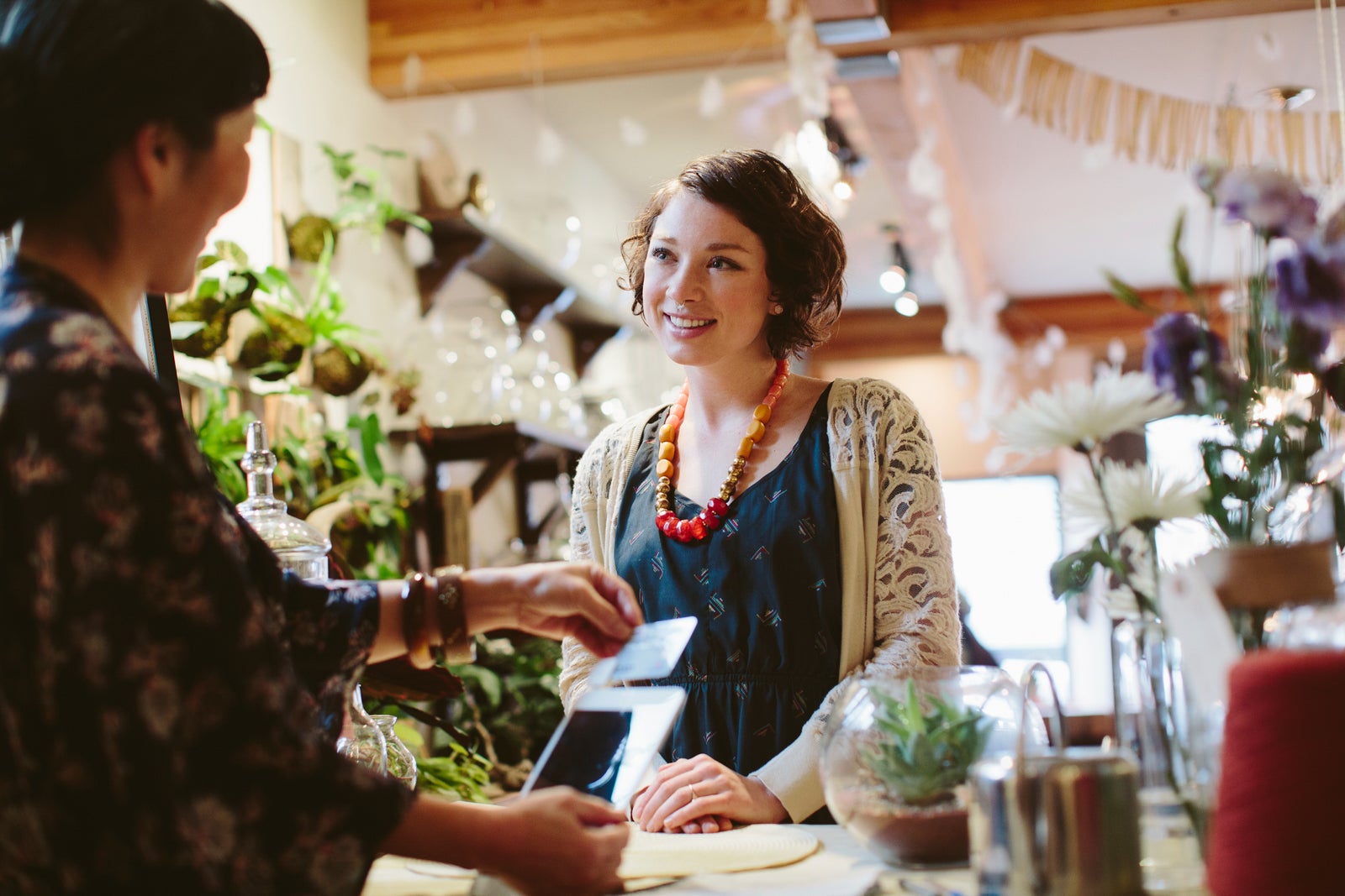 Owner using card reader for payment from customer in plant shop