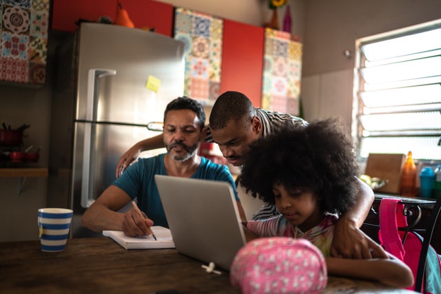 Parents helping daughter with homework at home