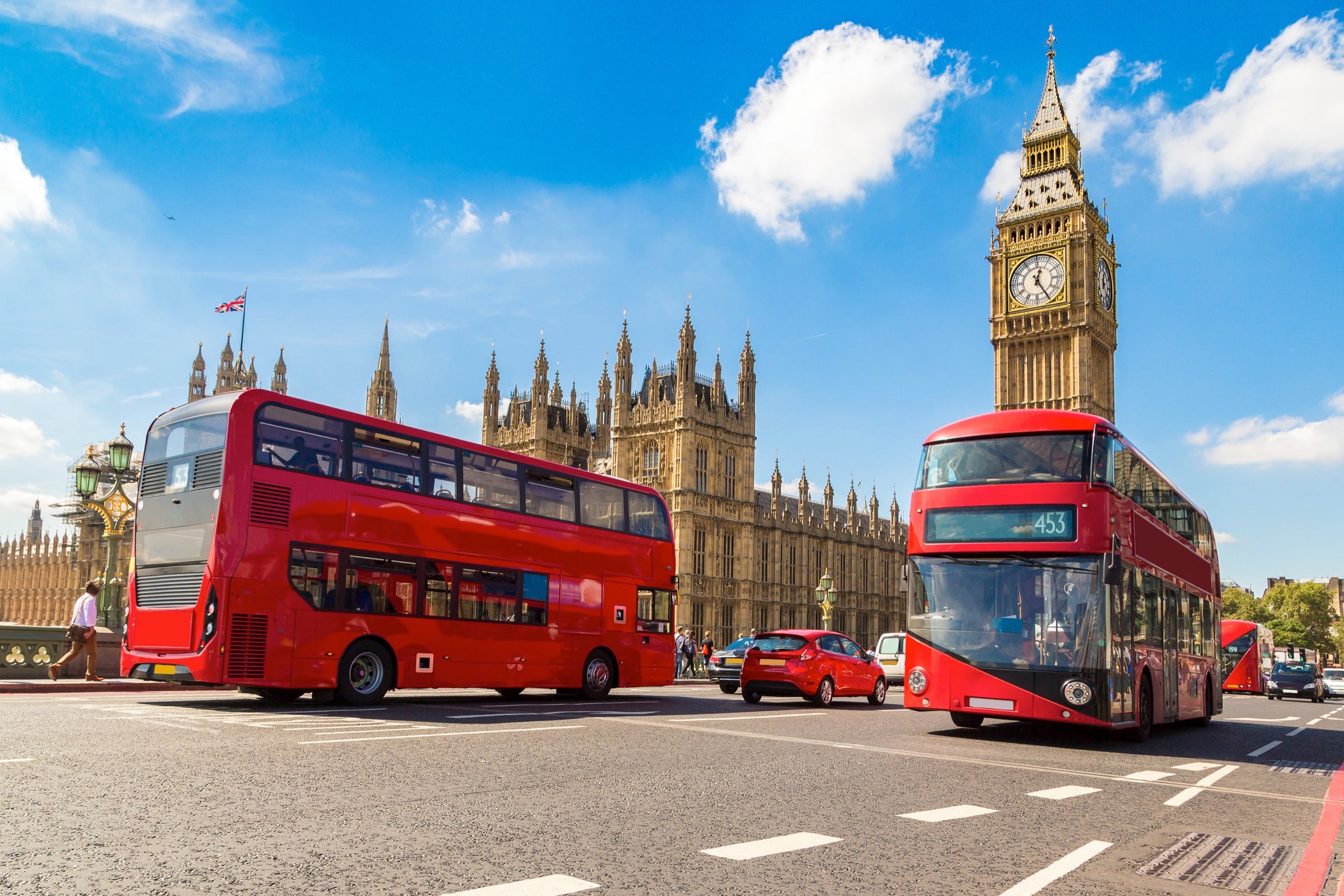 Double decker buses driving along Westminster Bridge in front of Big Ben in London