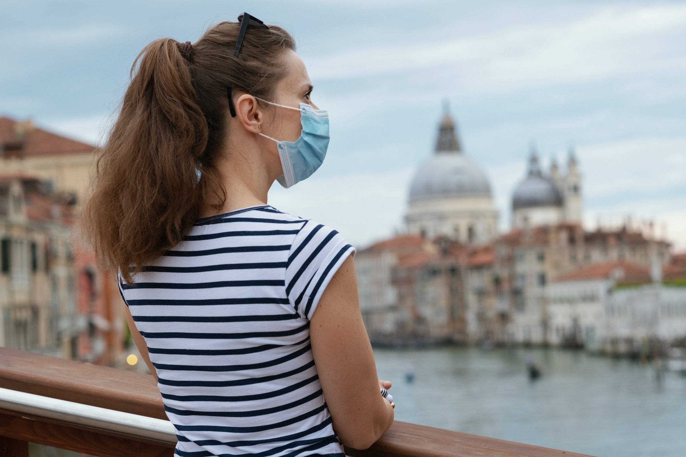 Female solo traveler wearing a blue medical mask
