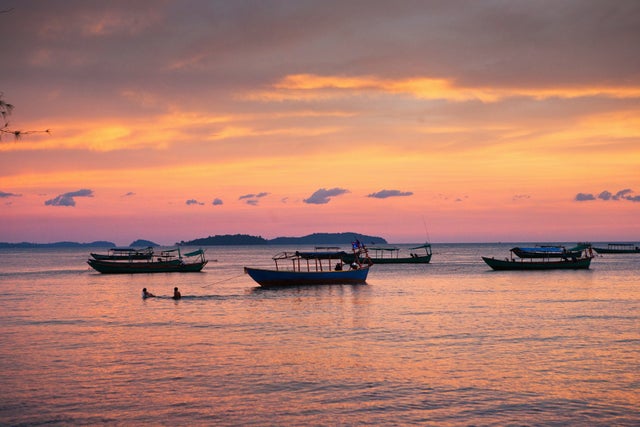 Boats float in solitude during sunset.