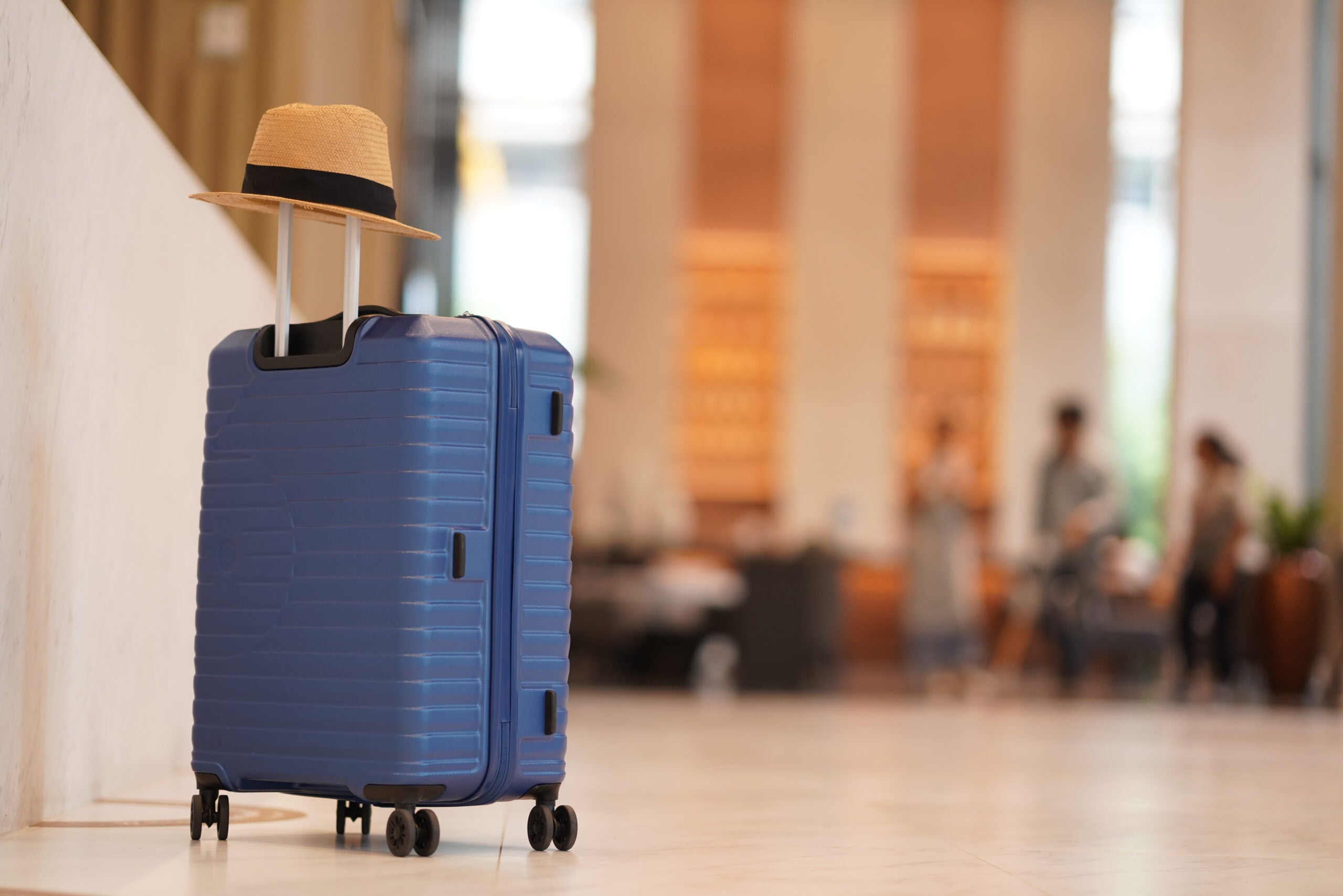 Luggage with sun hat in hotel lobby