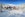 snow ski chalet/resort with snow-capped mountains, tall pine trees and people playing in the snow