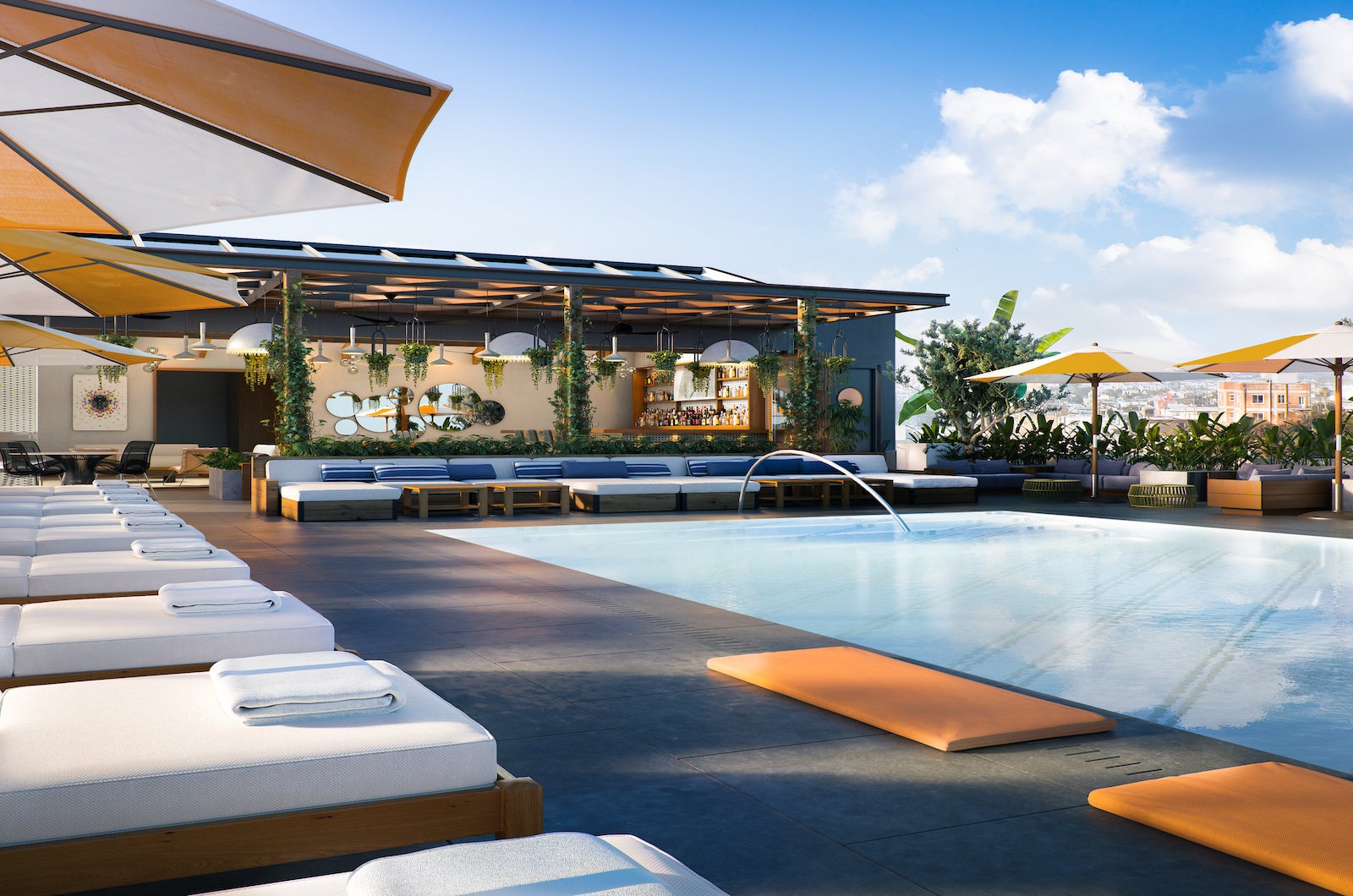 Rooftop pool and bar with lounge chairs and blue sky