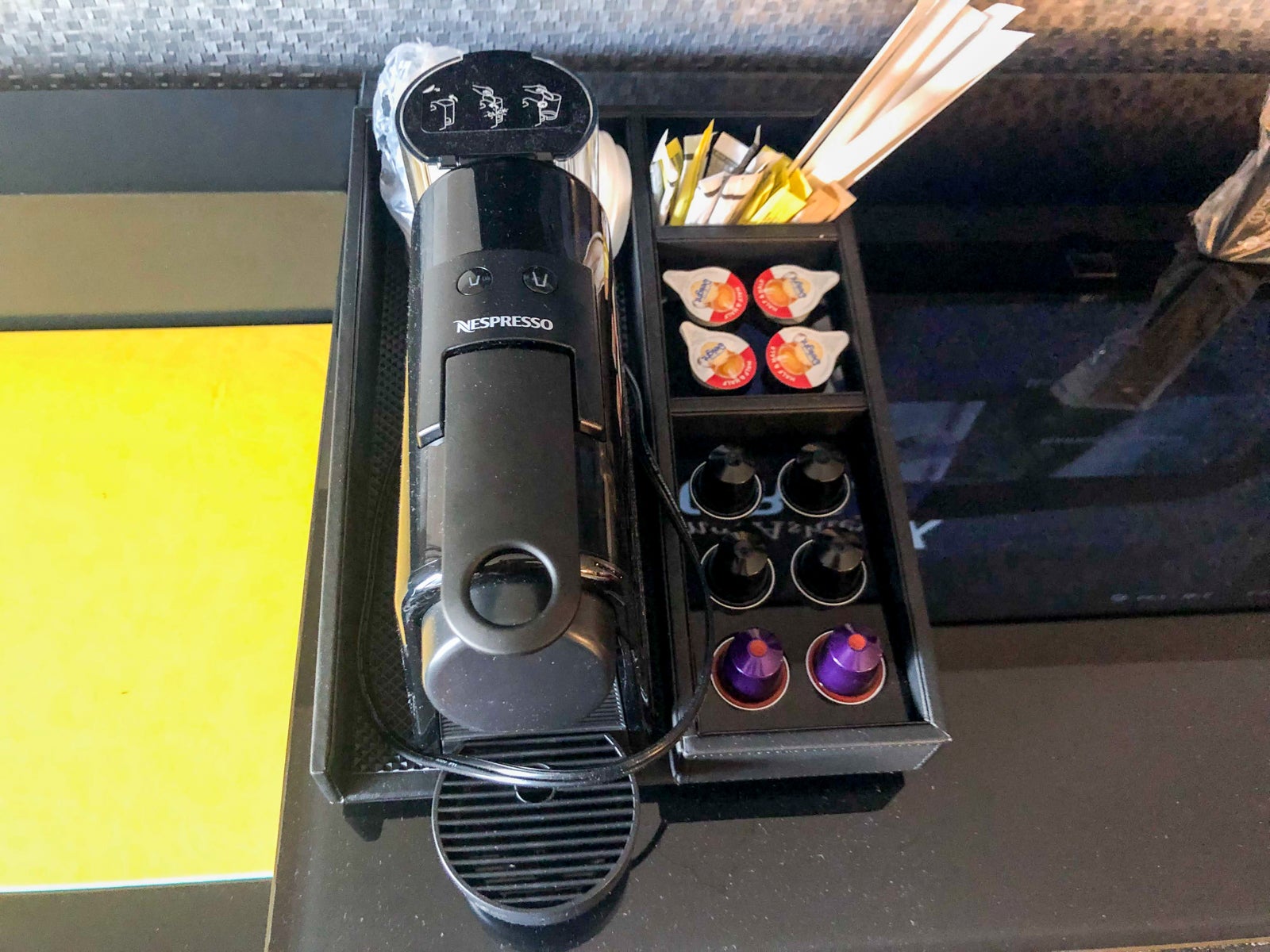 Nespresso machine with coffee pods, cream and sugar in the guestroom at The Clancy hotel.