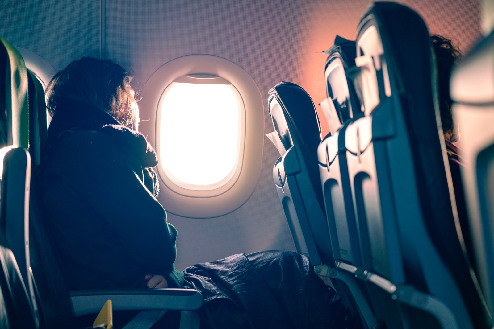 asian female traveller sit relax looking of of airplane window