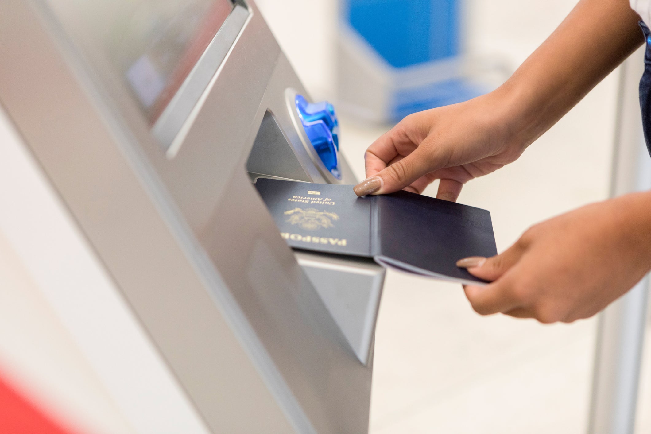 Unrecognizable woman scans passport at airport kiosk