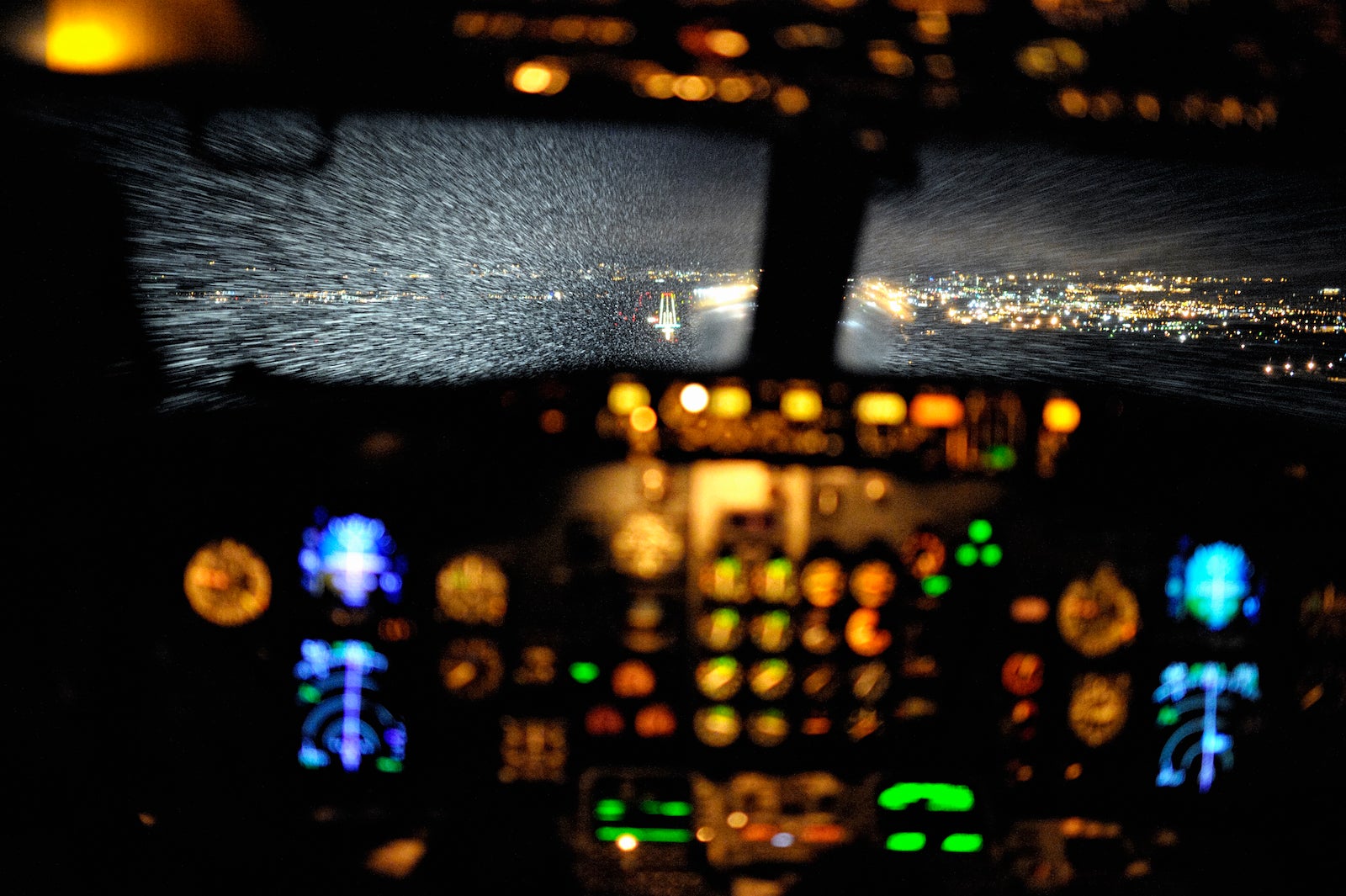 Cockpit View of Aircraft Approching Airport During Snowfall at Night