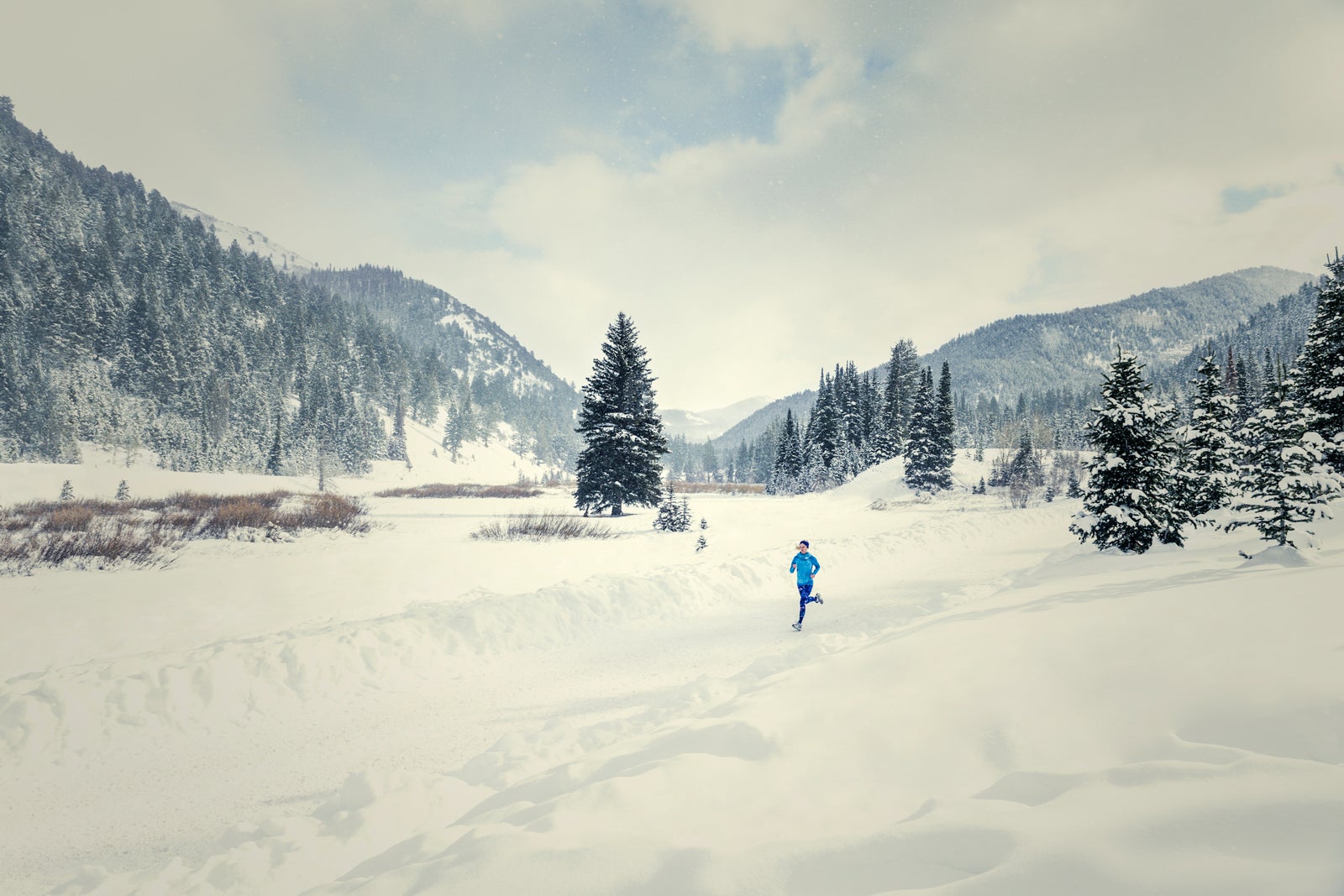 Caucasian woman running in snowy landscape