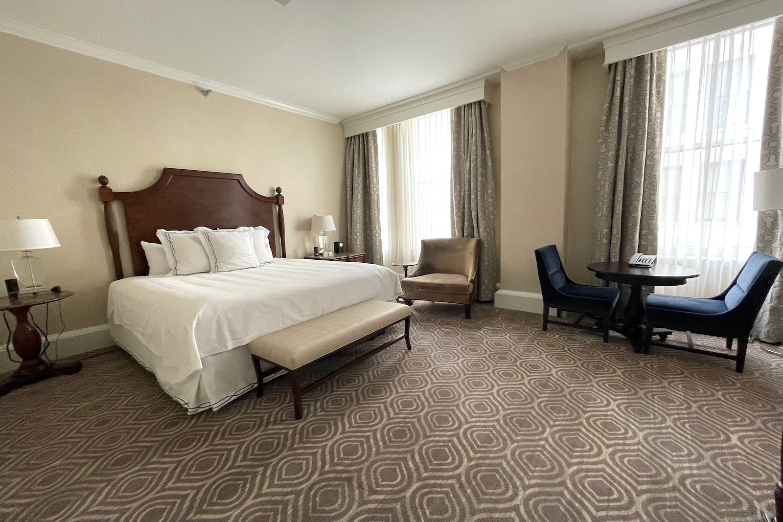 large hotel room with bed, chairs and table