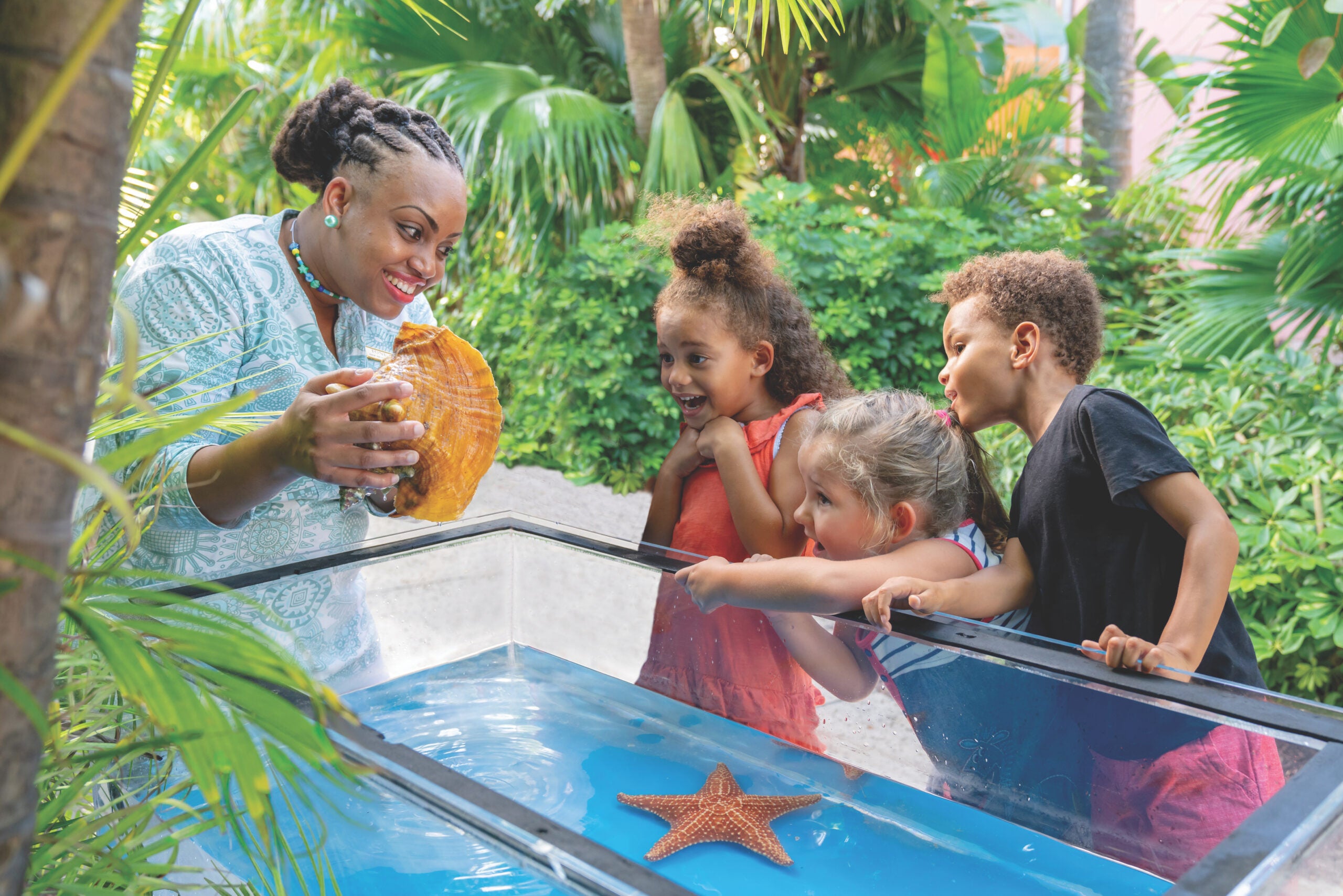 Kids looking at a conch as part of the Sea Squirts program at Atlantis Resort, Paradise Island in the Bahamas