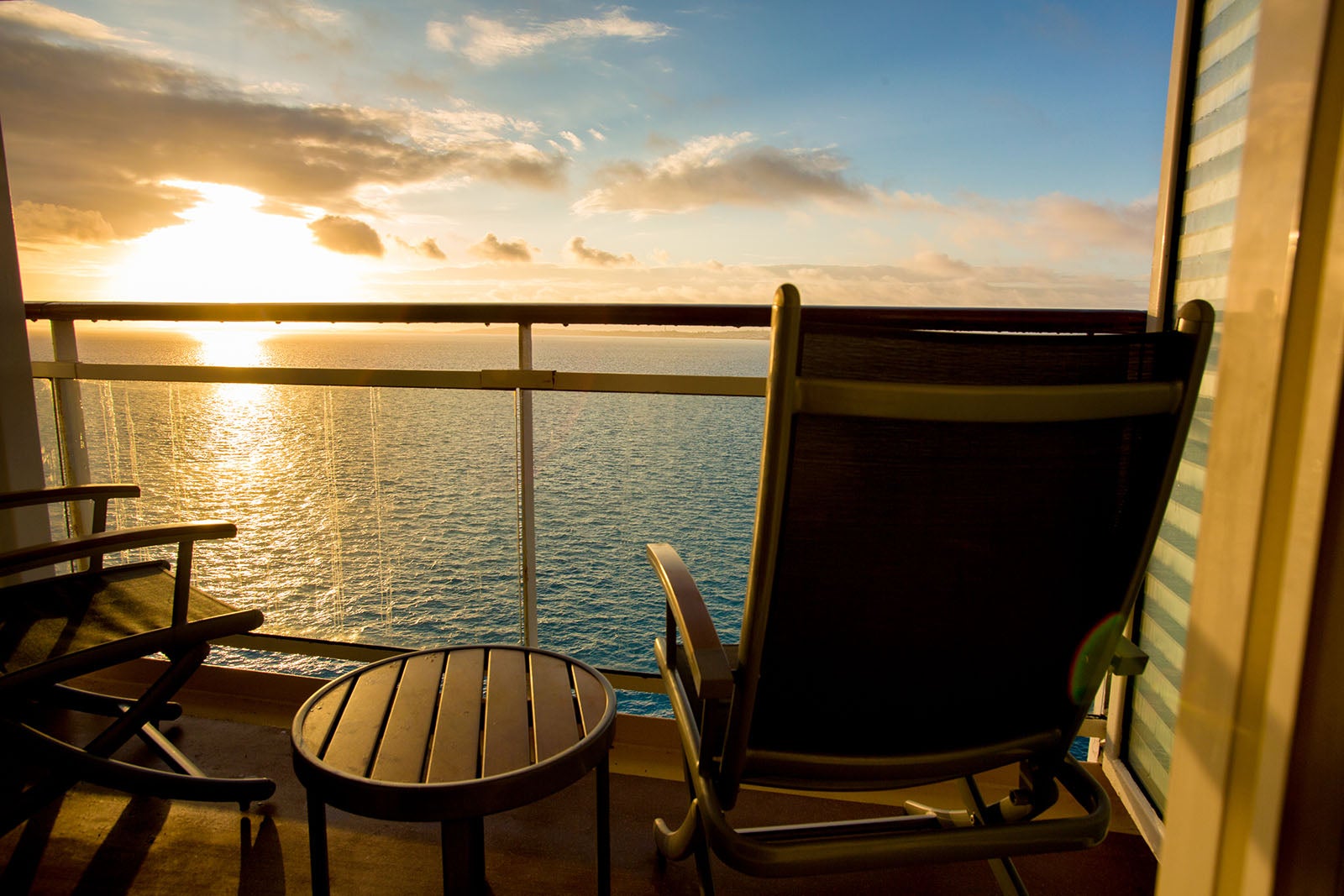 Calm scene of a deck chair at dusk viewing a beautiful sunset from a cruise ship