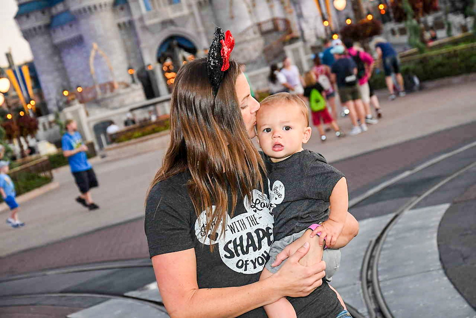 Tarah kissing her child on the cheek at Disney World
