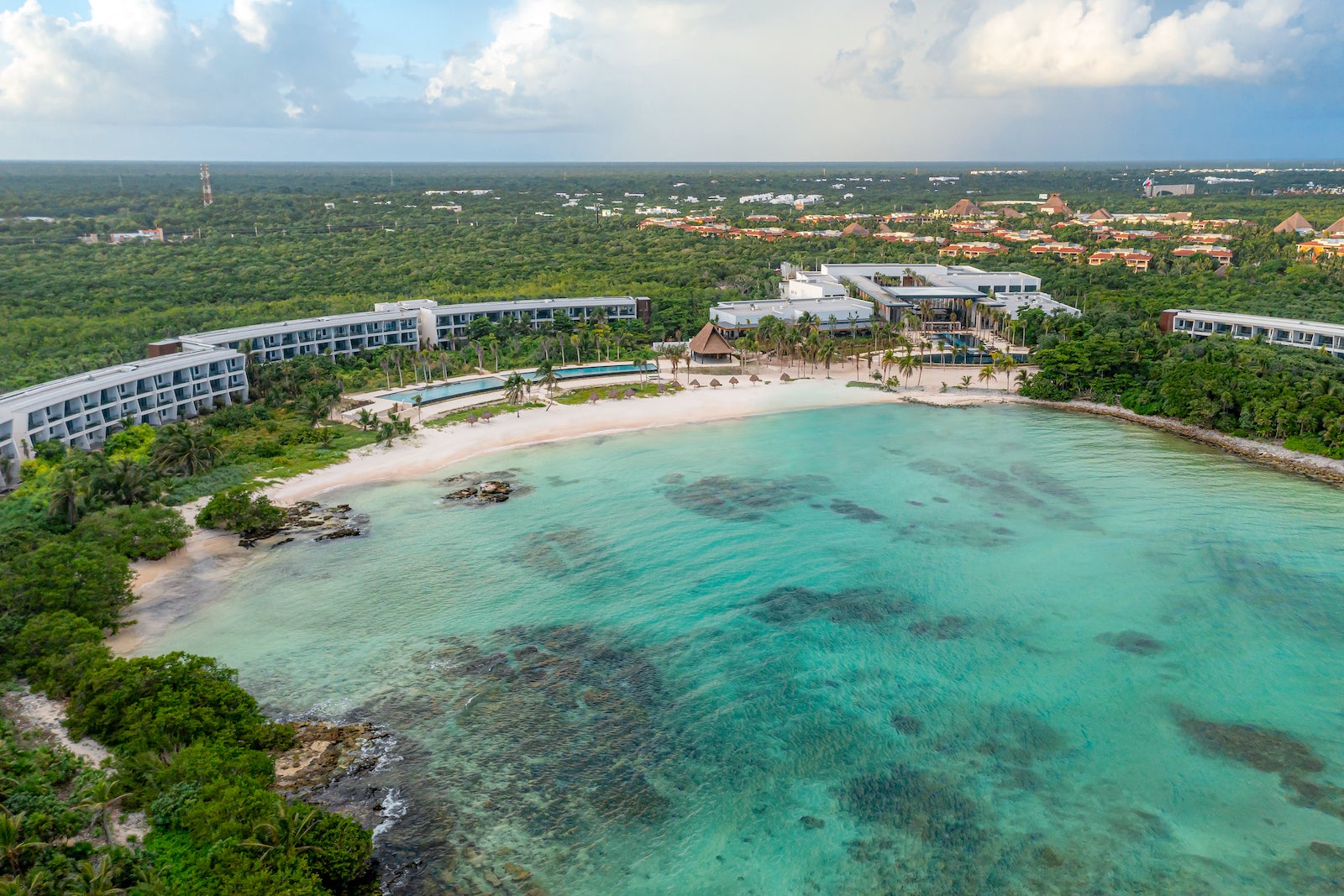 aerial photo of large white resort around bay with turquoise water