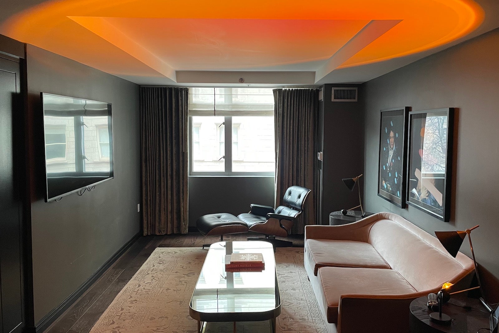 hotel living room with couch facing tv and sunset lamp projecting on ceiling
