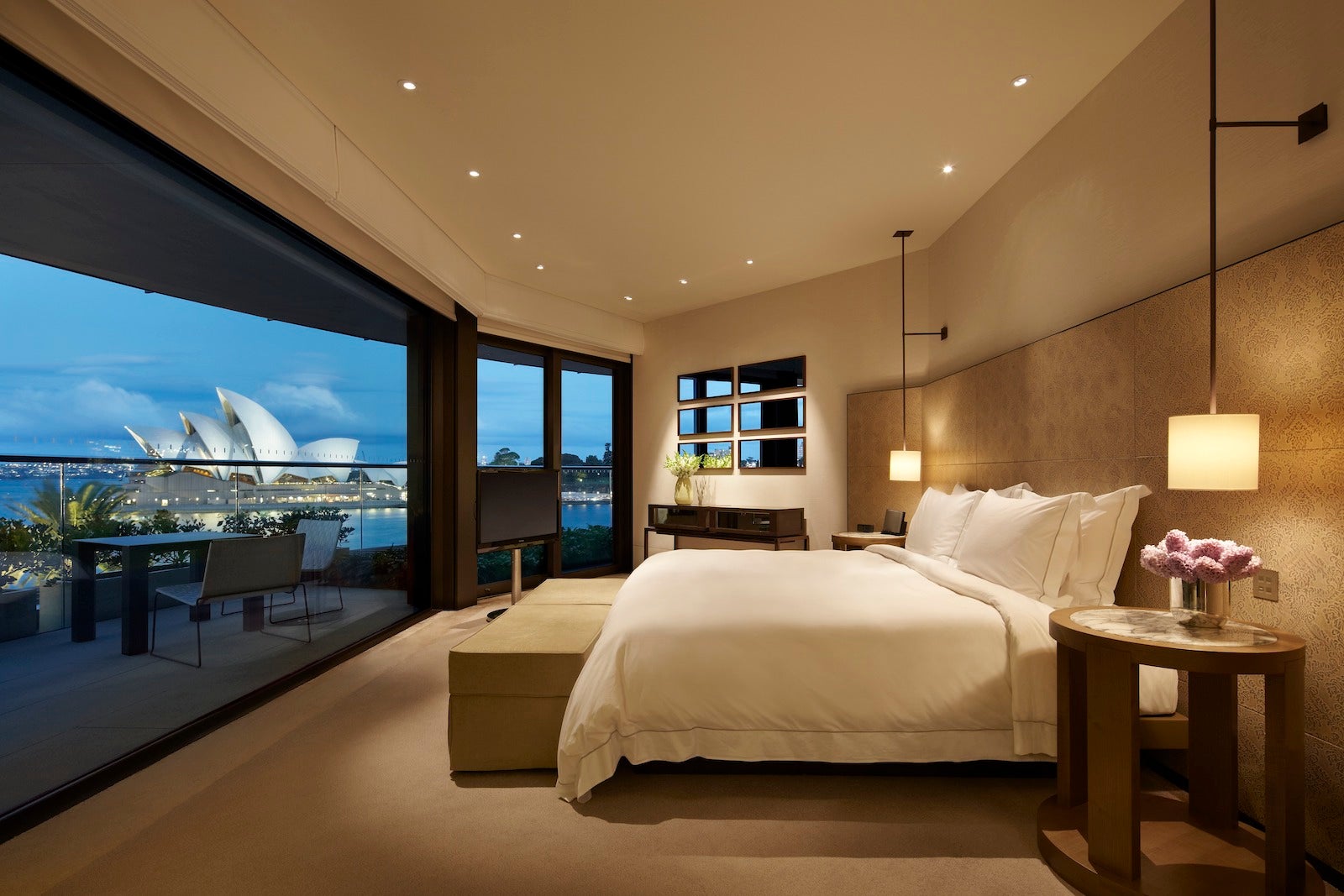 hotel room with wrap-around windows with views of the Sydney Opera house