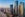 three large, modern skyscrapers set off from beach and large city