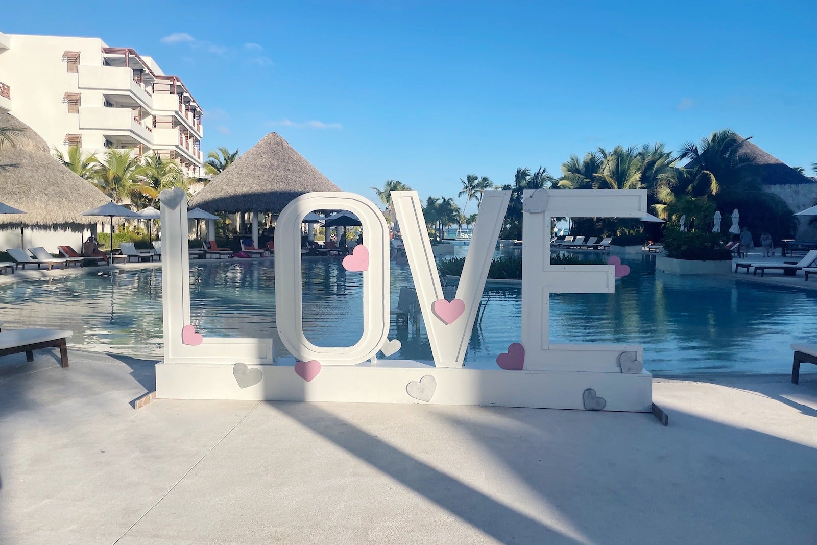 giant love sign in front of pool