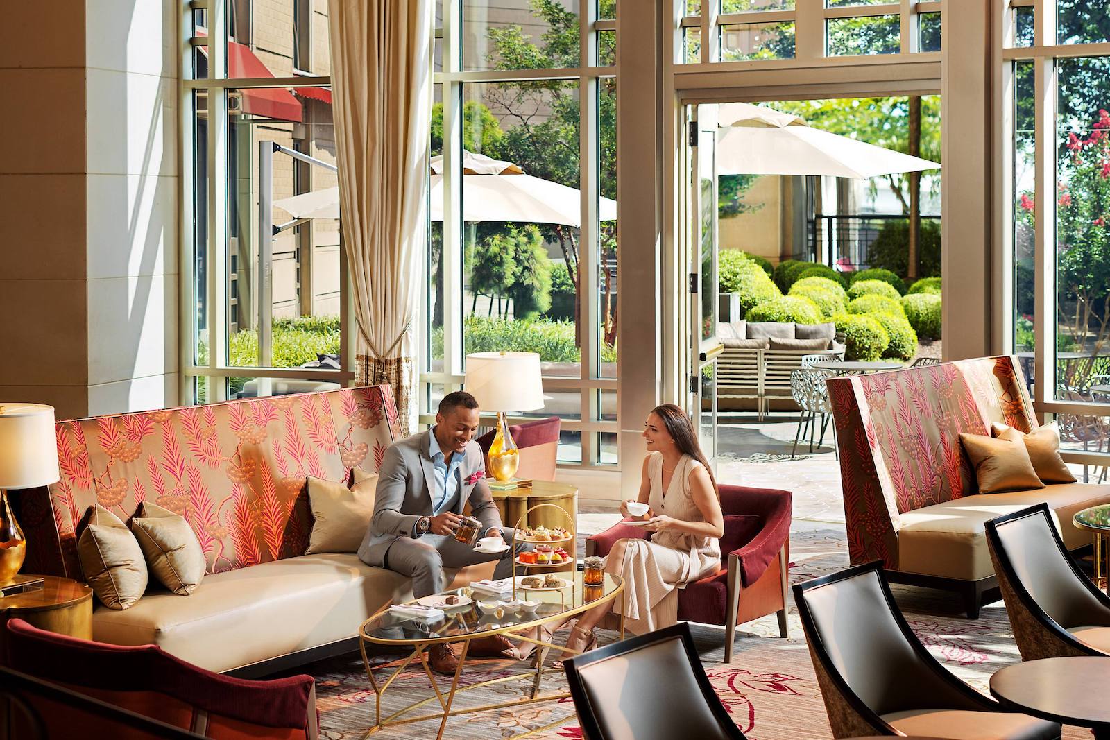 hotel lobby with couple drinking tea on couches and arm chair