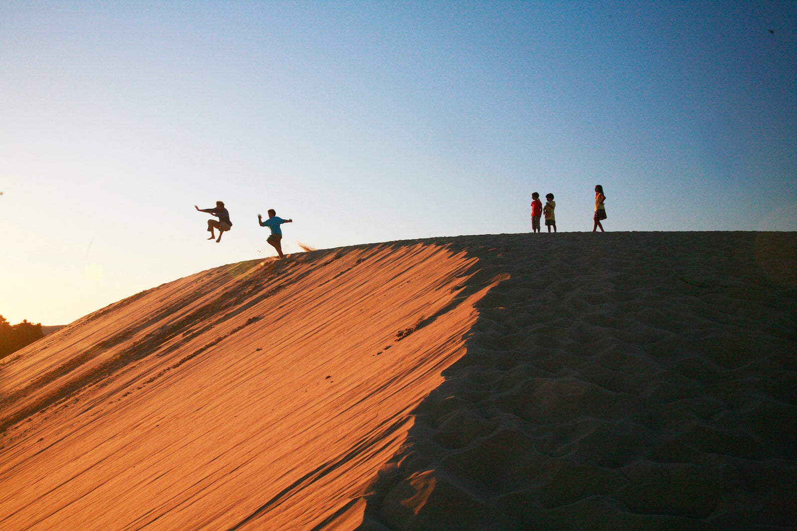 Children playing on sand dunes