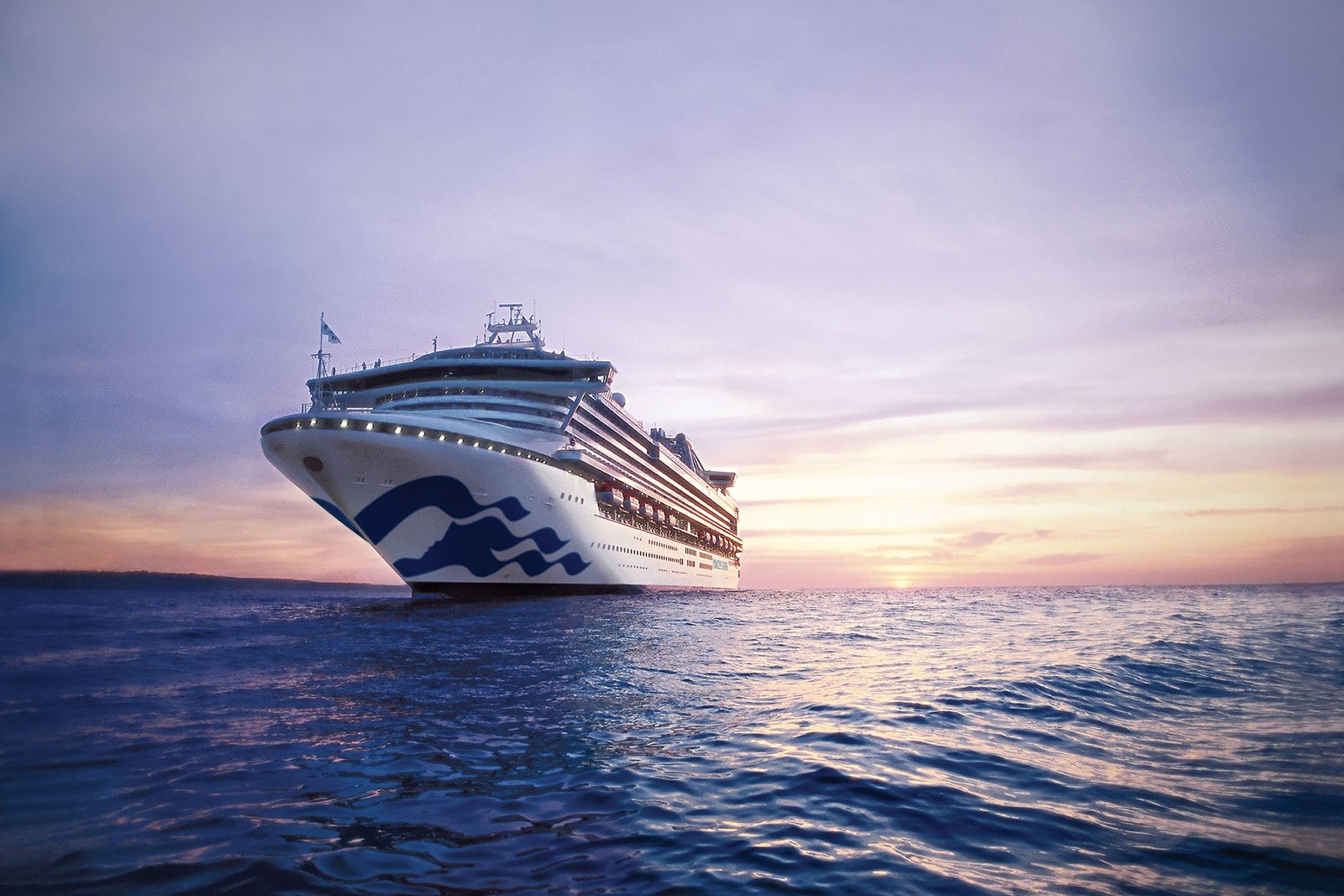 Sapphire Princess cruise ship sailing in ocean as sun sets