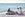 bedouin man and couple sitting on beach eating food