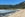 Woman walking on beach with green mountains behind her
