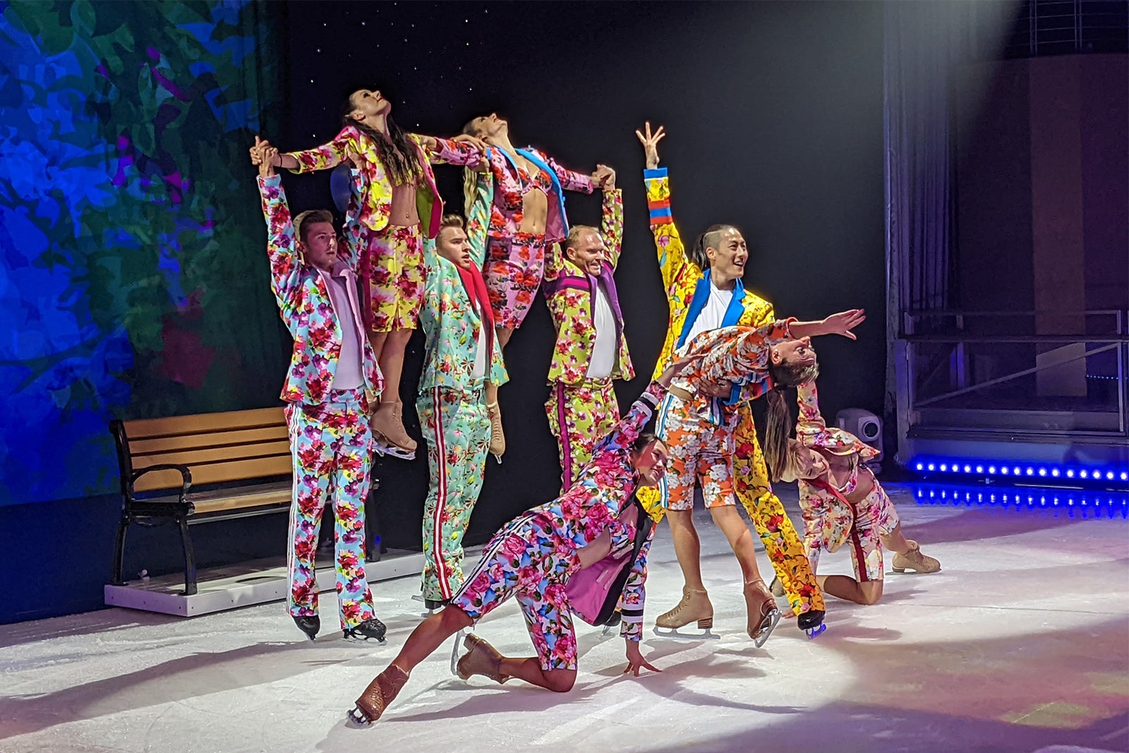 Ice skaters pose in colorful floral costumes