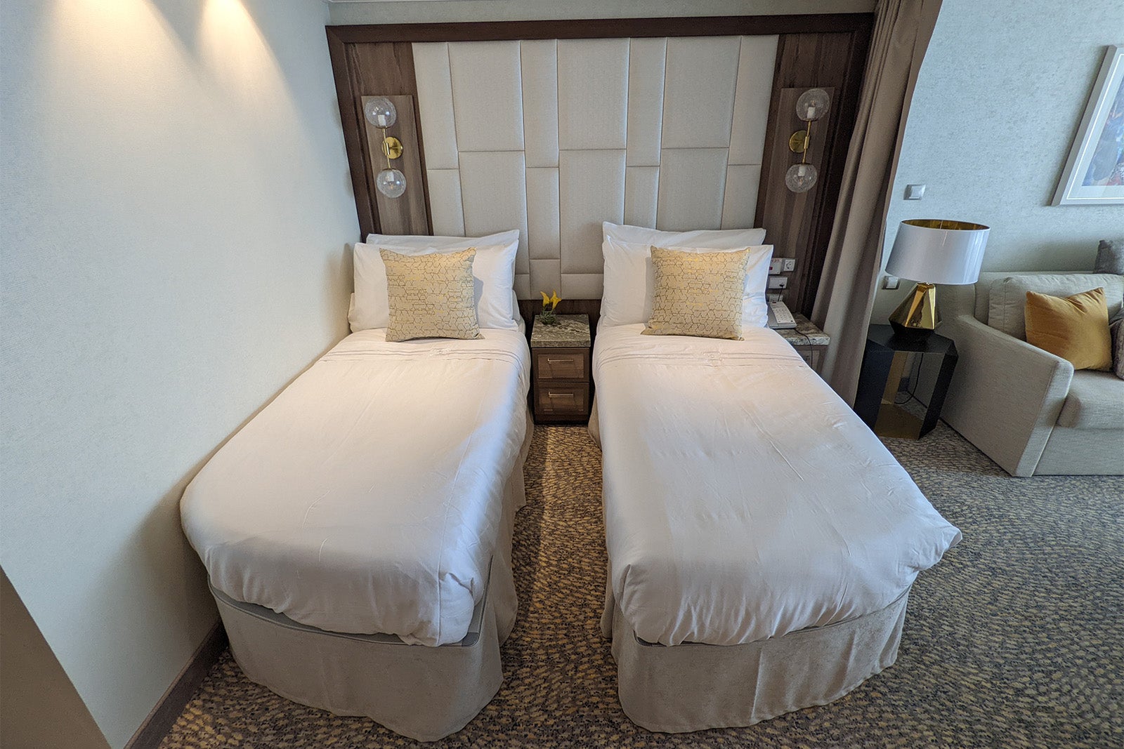 Twin beds with white linens in cruise ship suite