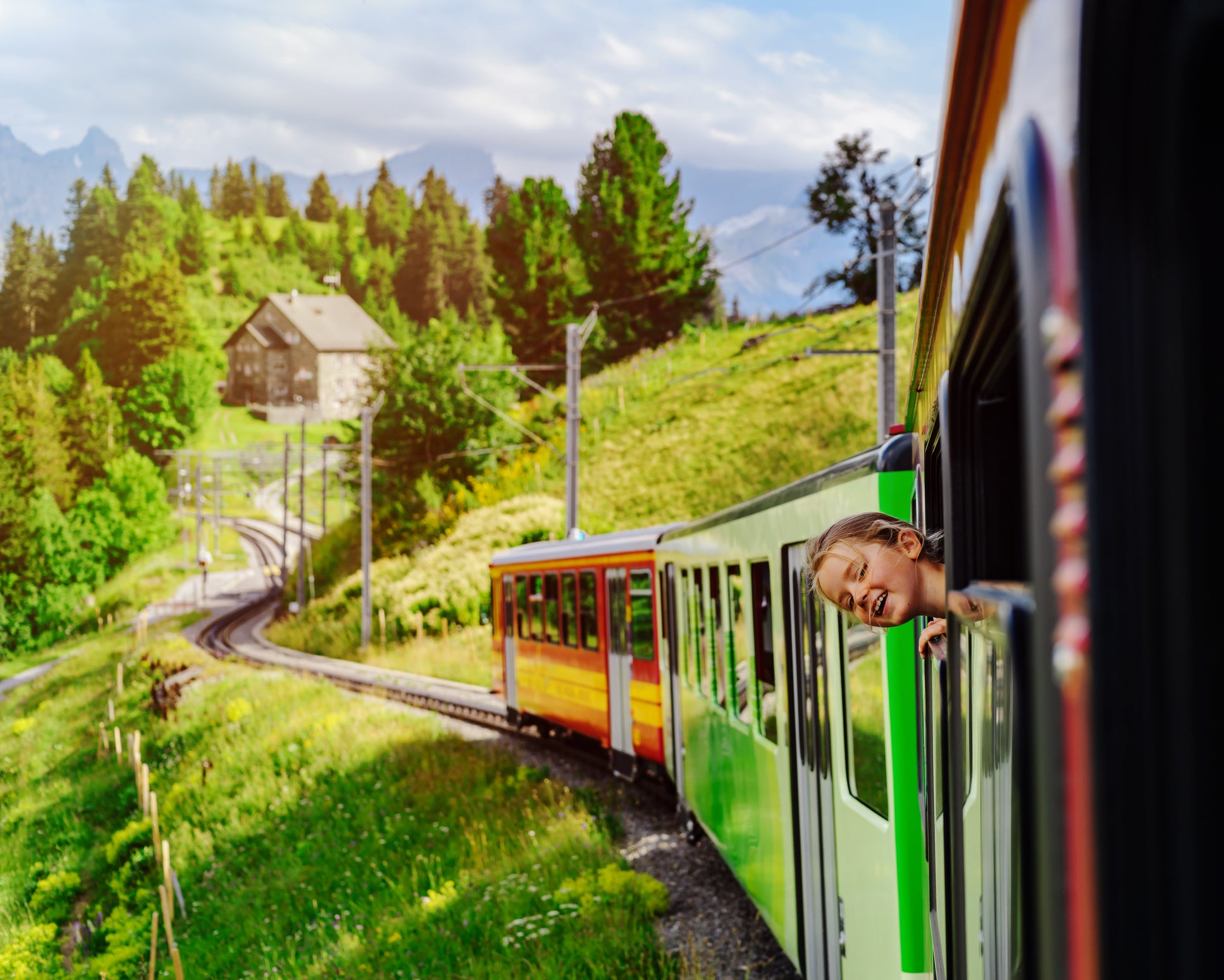 Little girl looking through the window of alpine train