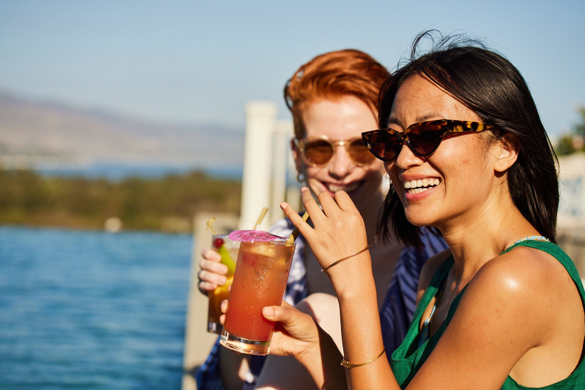 Two woman enjoying drinks on the water