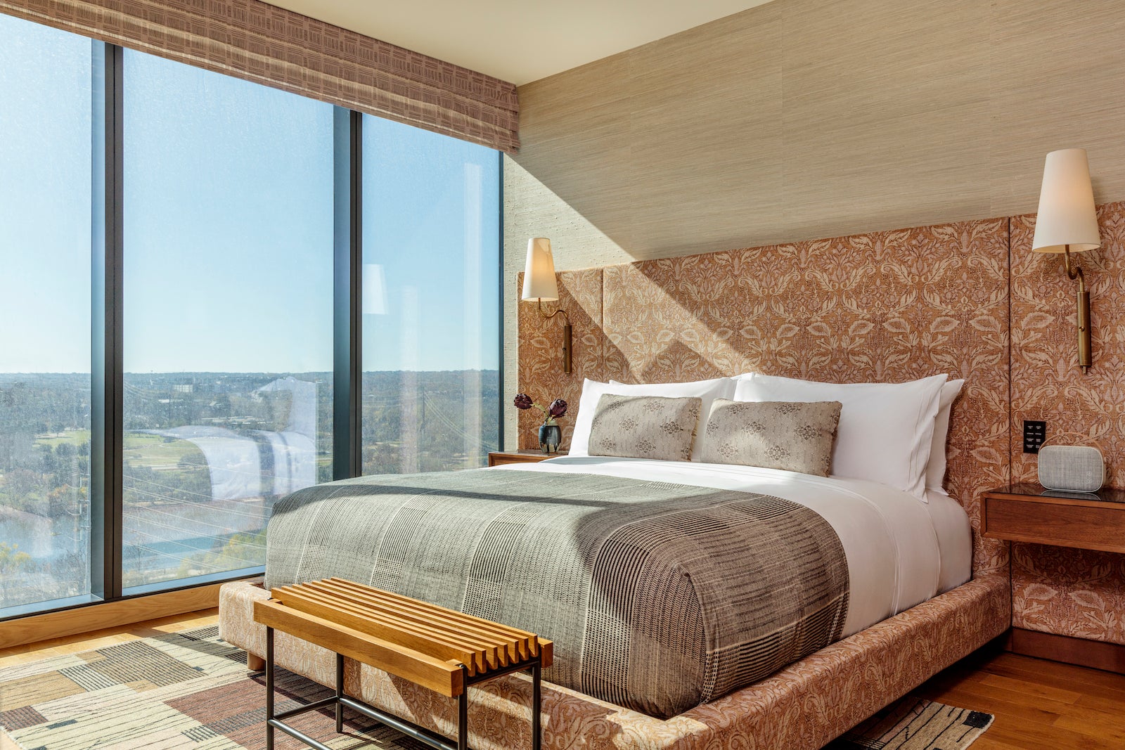 upholstered headboard and floor-to-ceiling windows looking over water