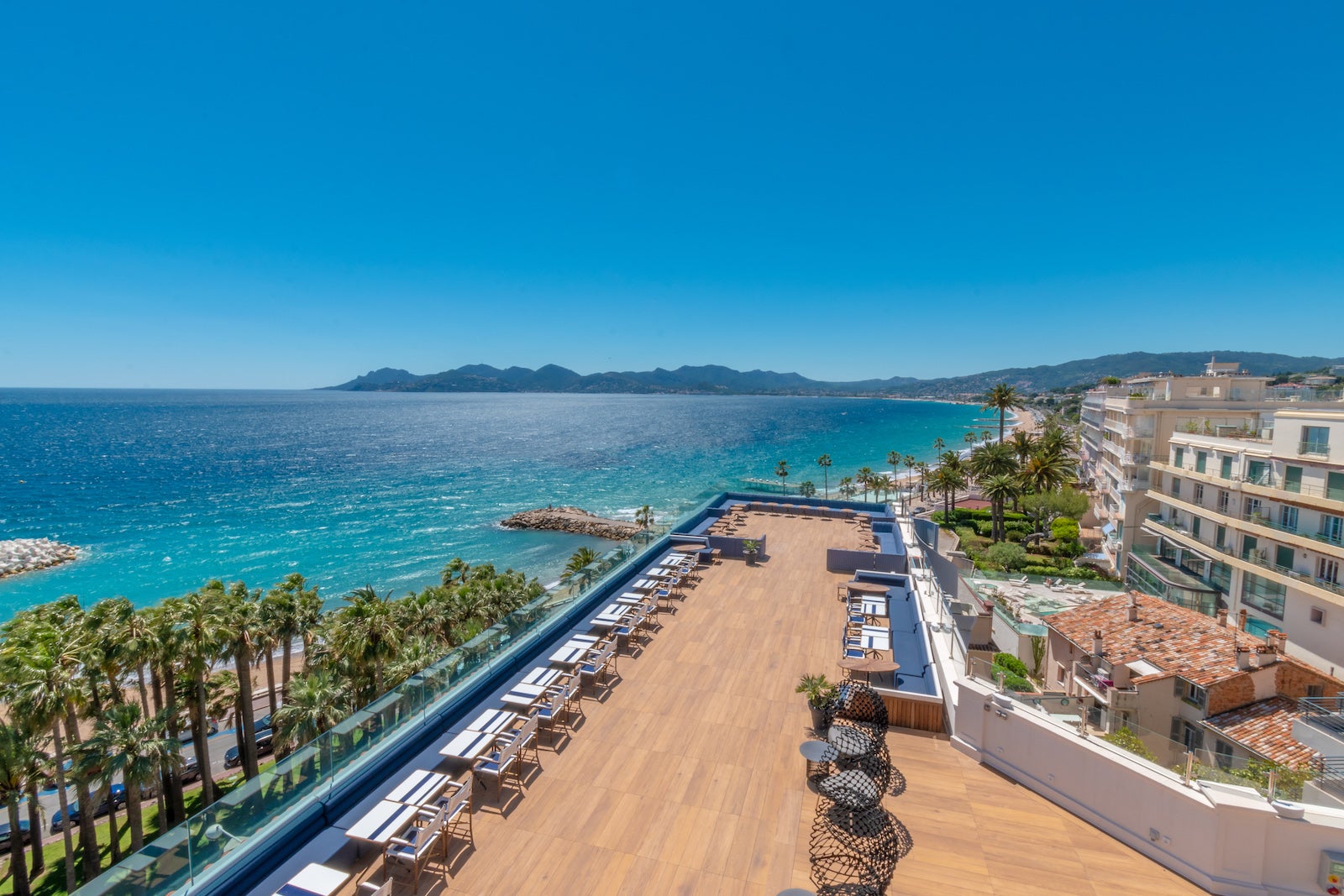 view of roof deck overlooking blue waters and beach