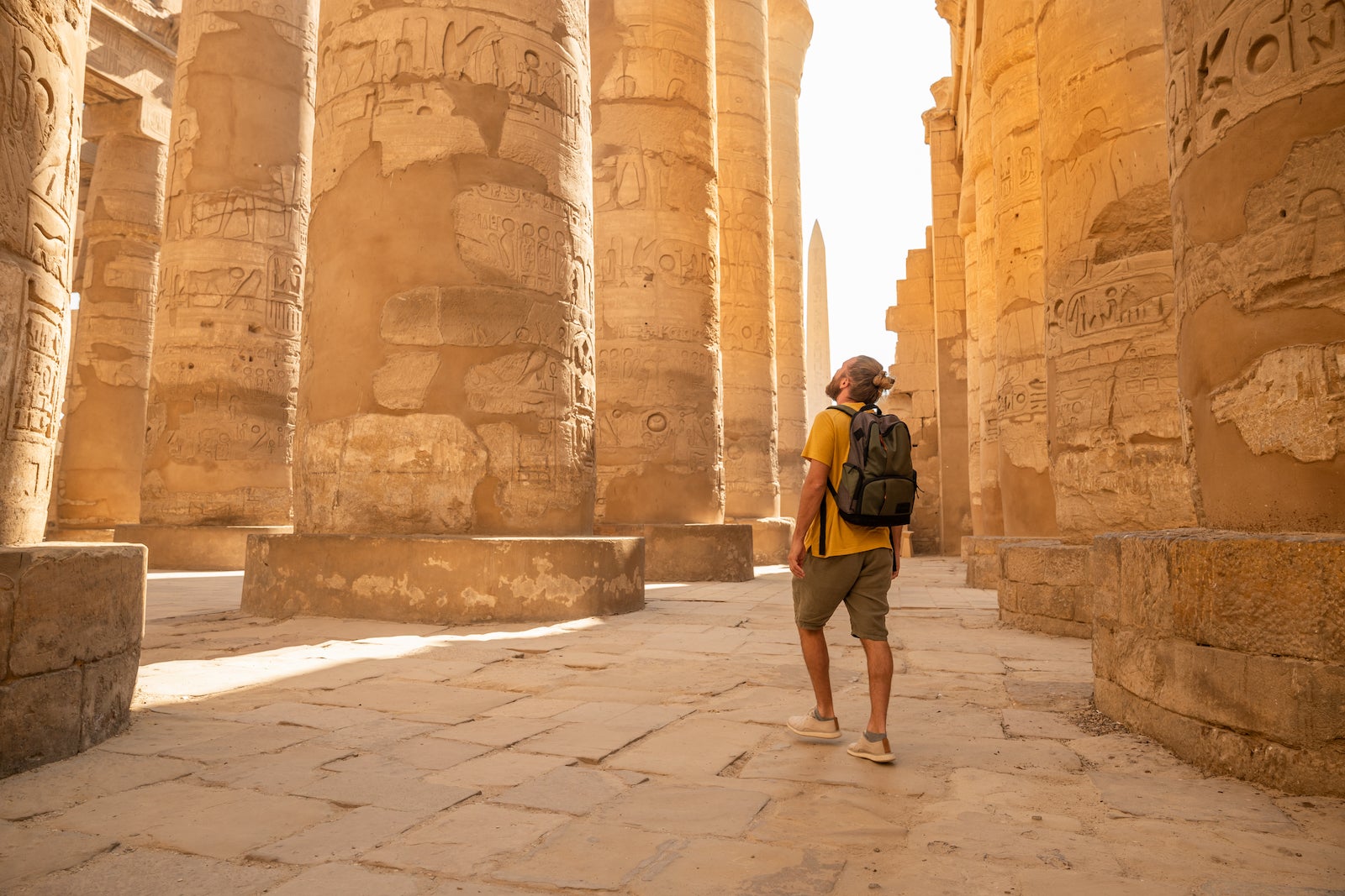 man in shorts walking along giant pillars