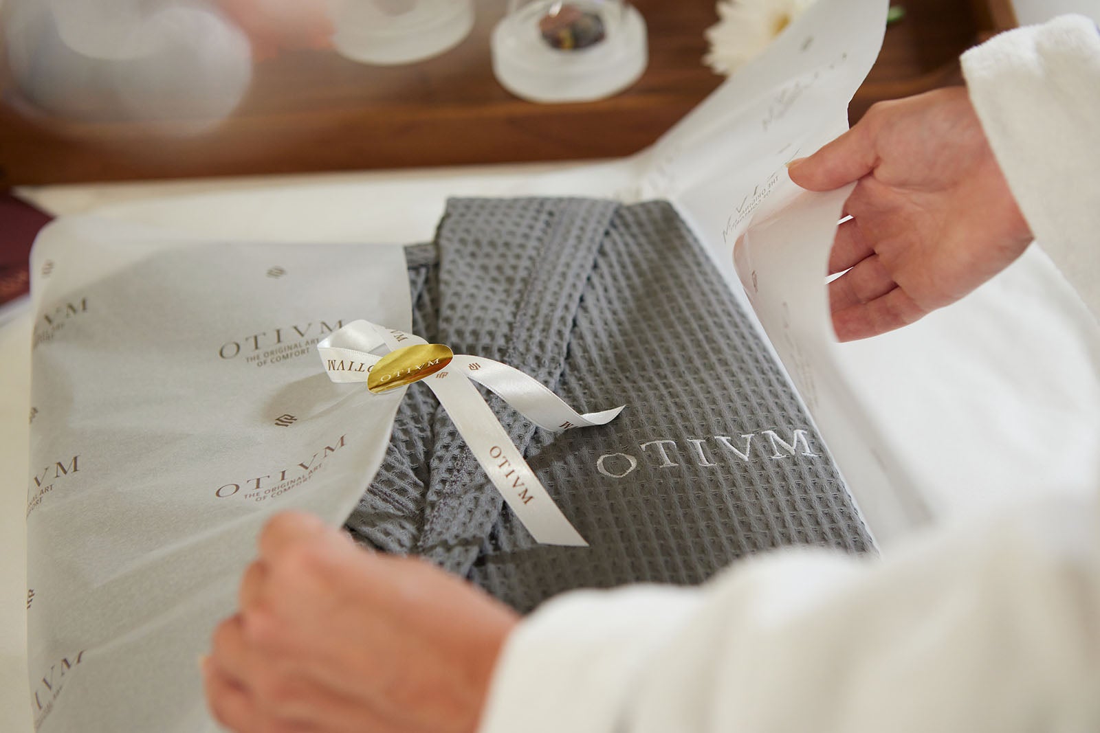 Gray bathrobe in tissue paper with Otium label