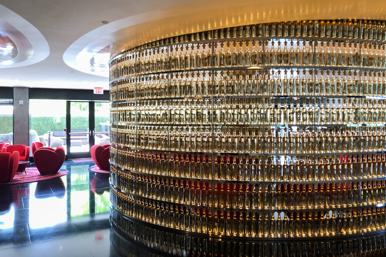 A curved wall of empty bottles hides The Watergate Hotel's lobby bar.