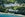 aerial view of large white resort on lake with beach access and waterpark