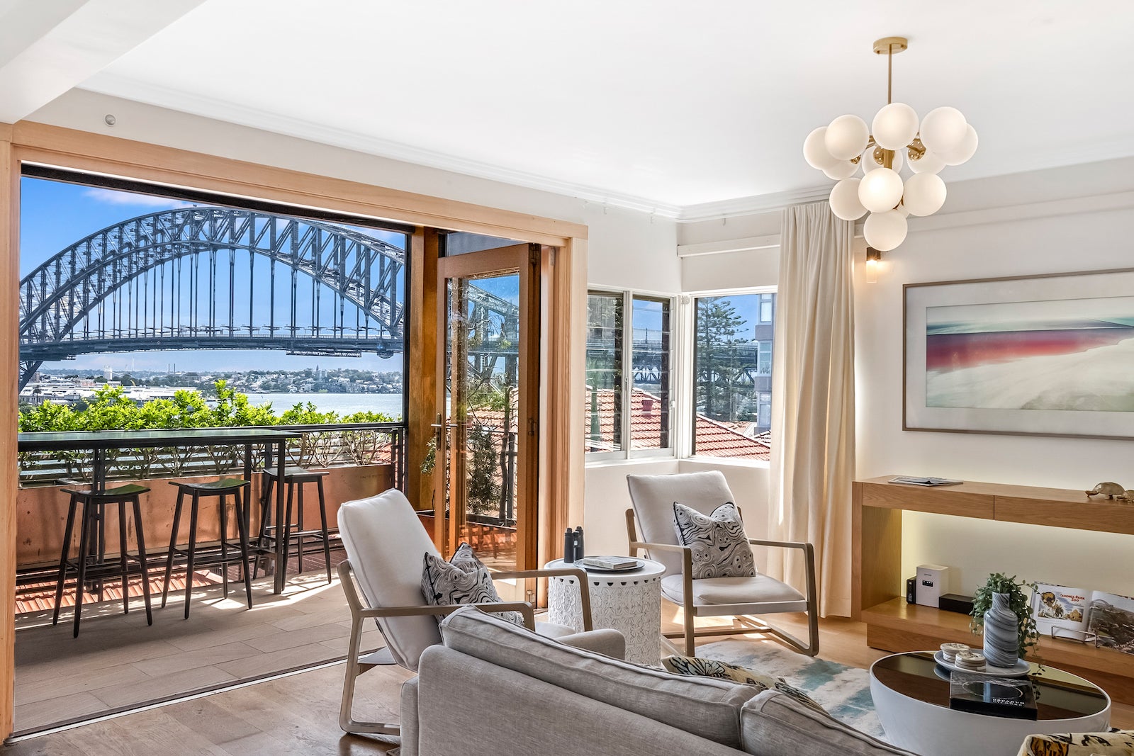 living room with lounge chairs and balcony looking out over Sydney Harbour Bridge